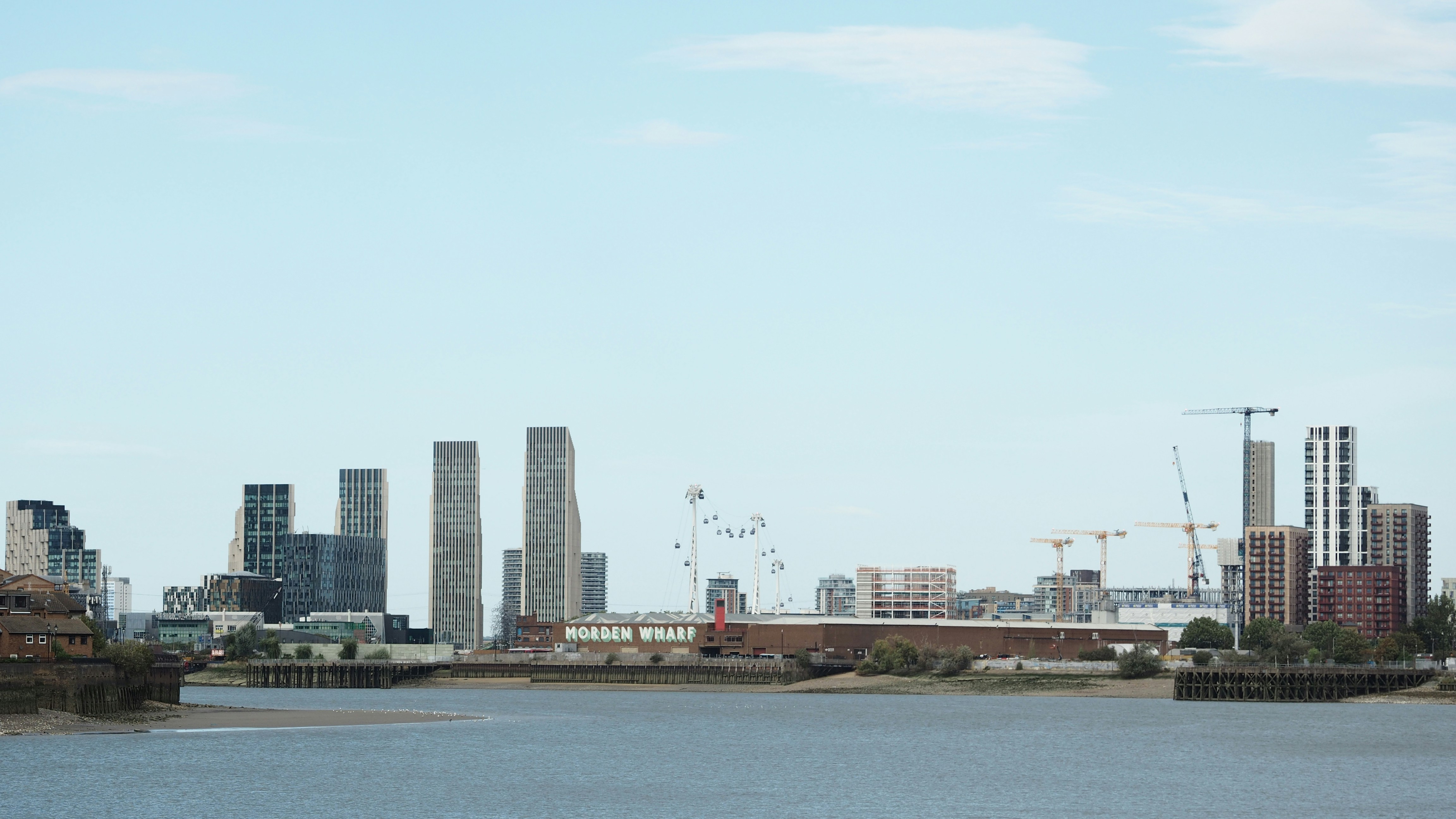 O galpão Morden Wharf e edifícios modernos de alto nível ao longo do rio Tâmisa, em Londres