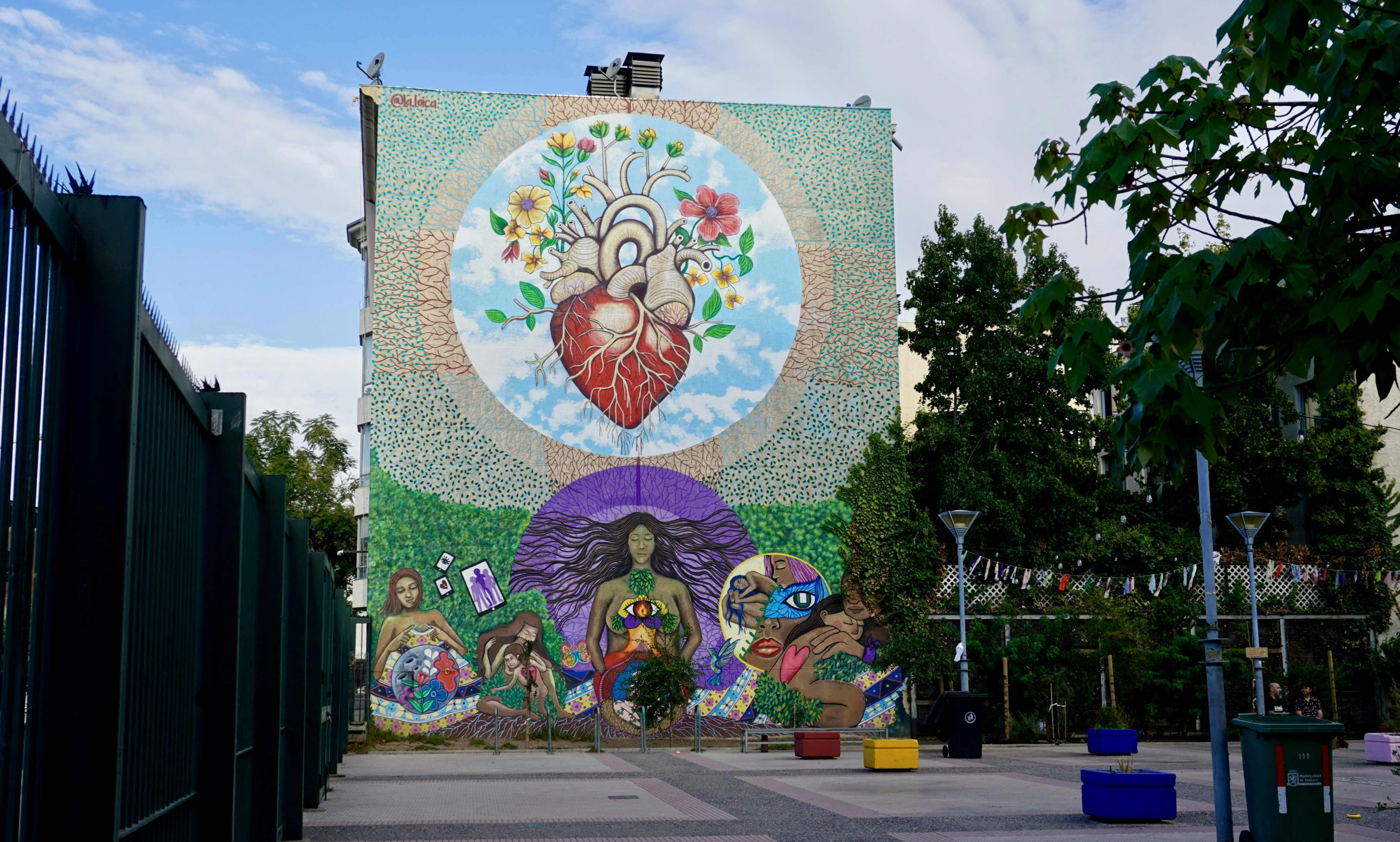 A large mural of an anatomical heart and people on a building wall