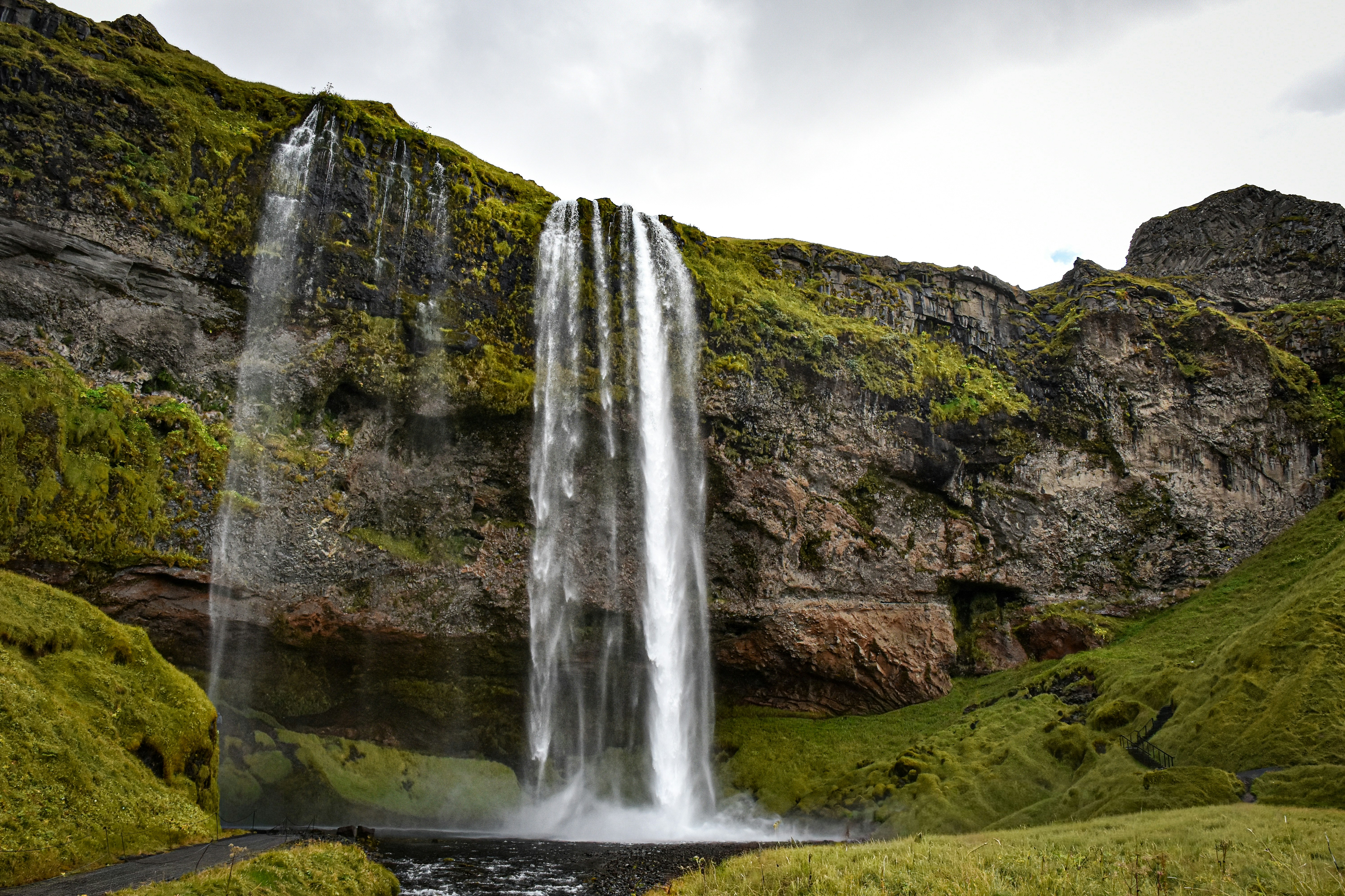 Cachoeira Seljalandsfoss caindo sobre um penhasco musgoso na Islândia