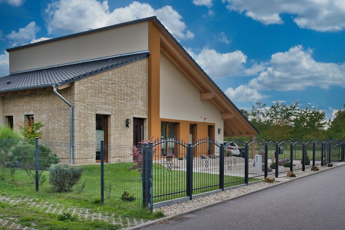 Maison moderne en brique avec clôture métallique