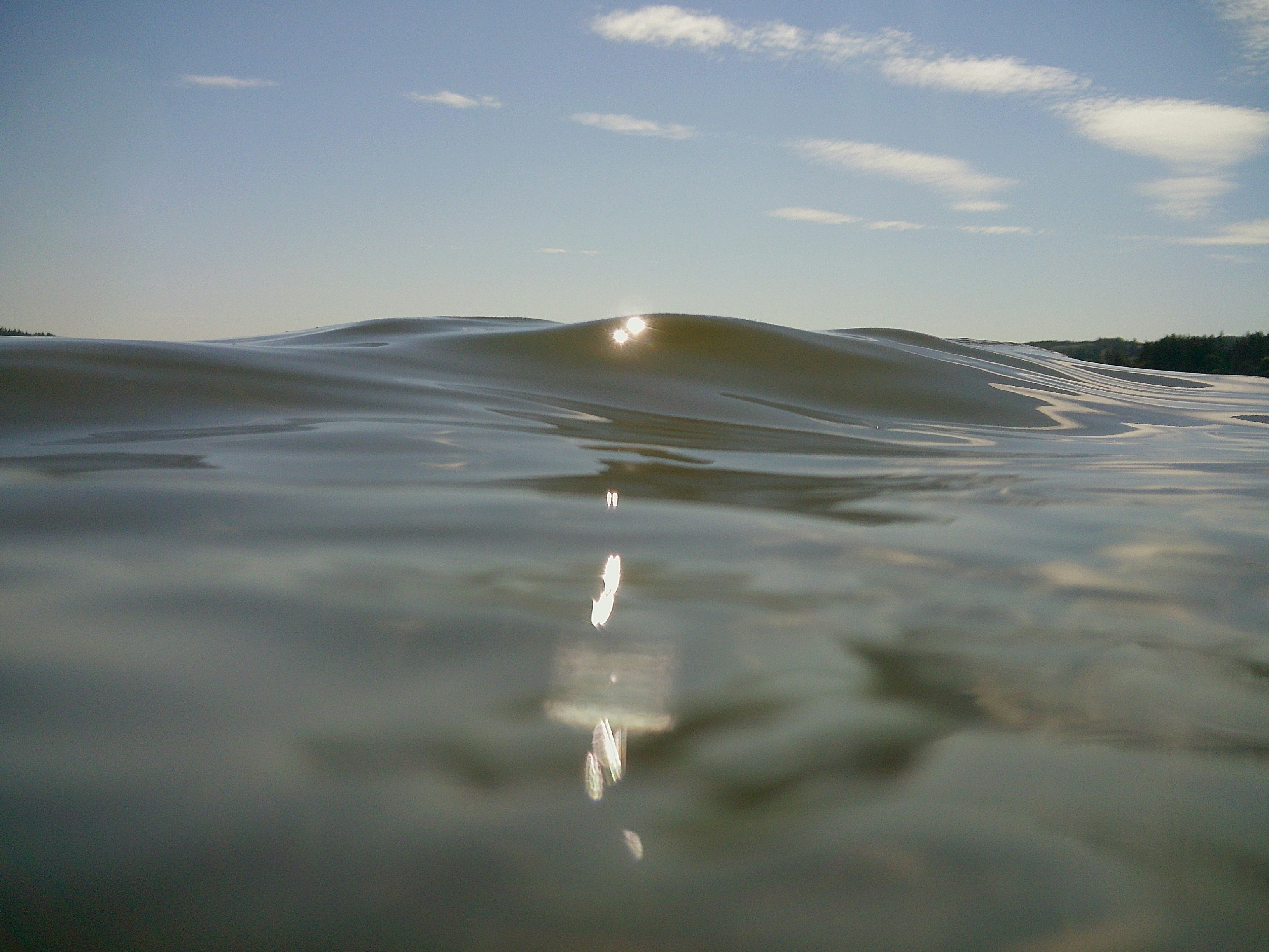 Low sun reflecting on the surface of calm water under a clear sky