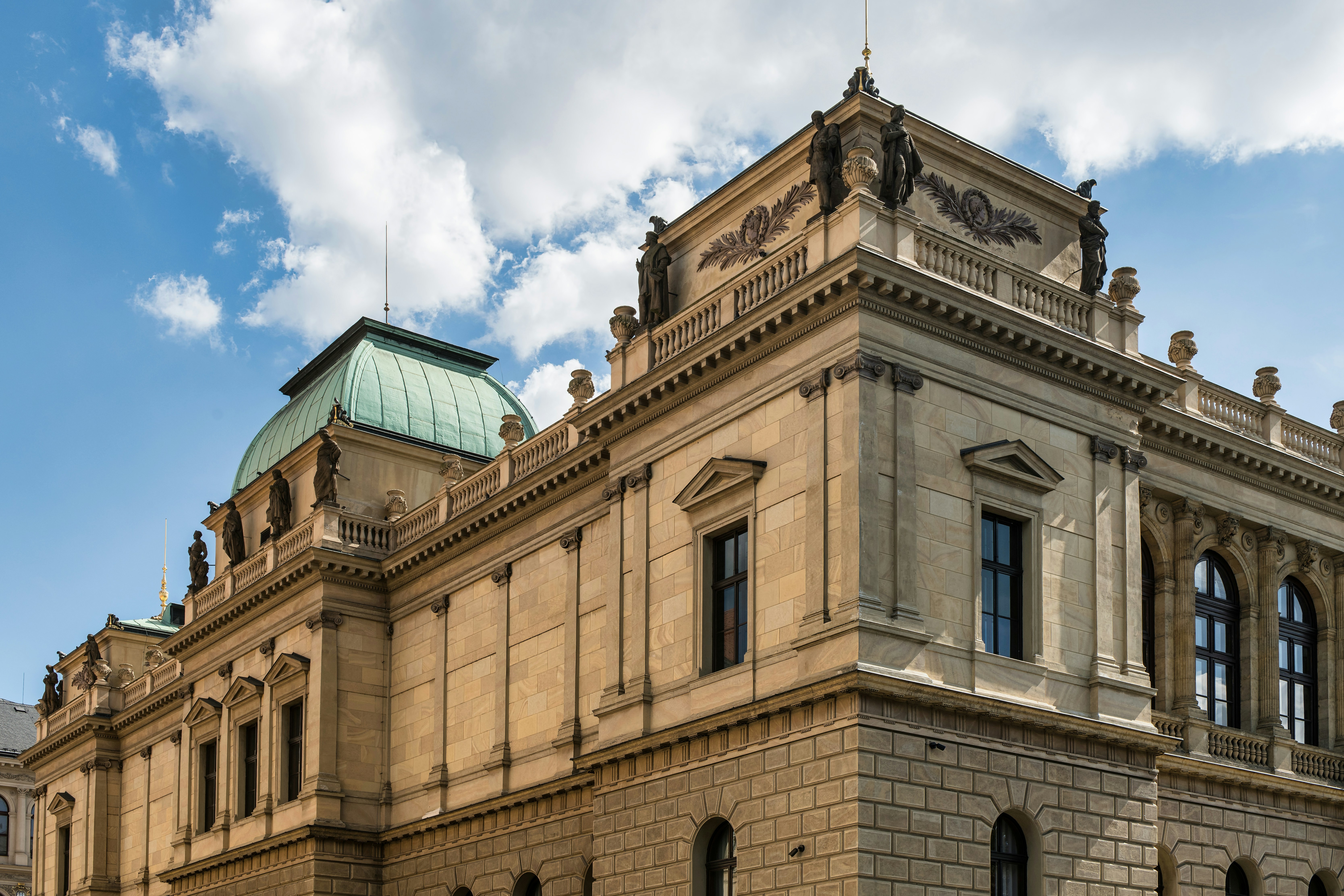 The green dome and stone facade of the Rudolfinum building in Prague