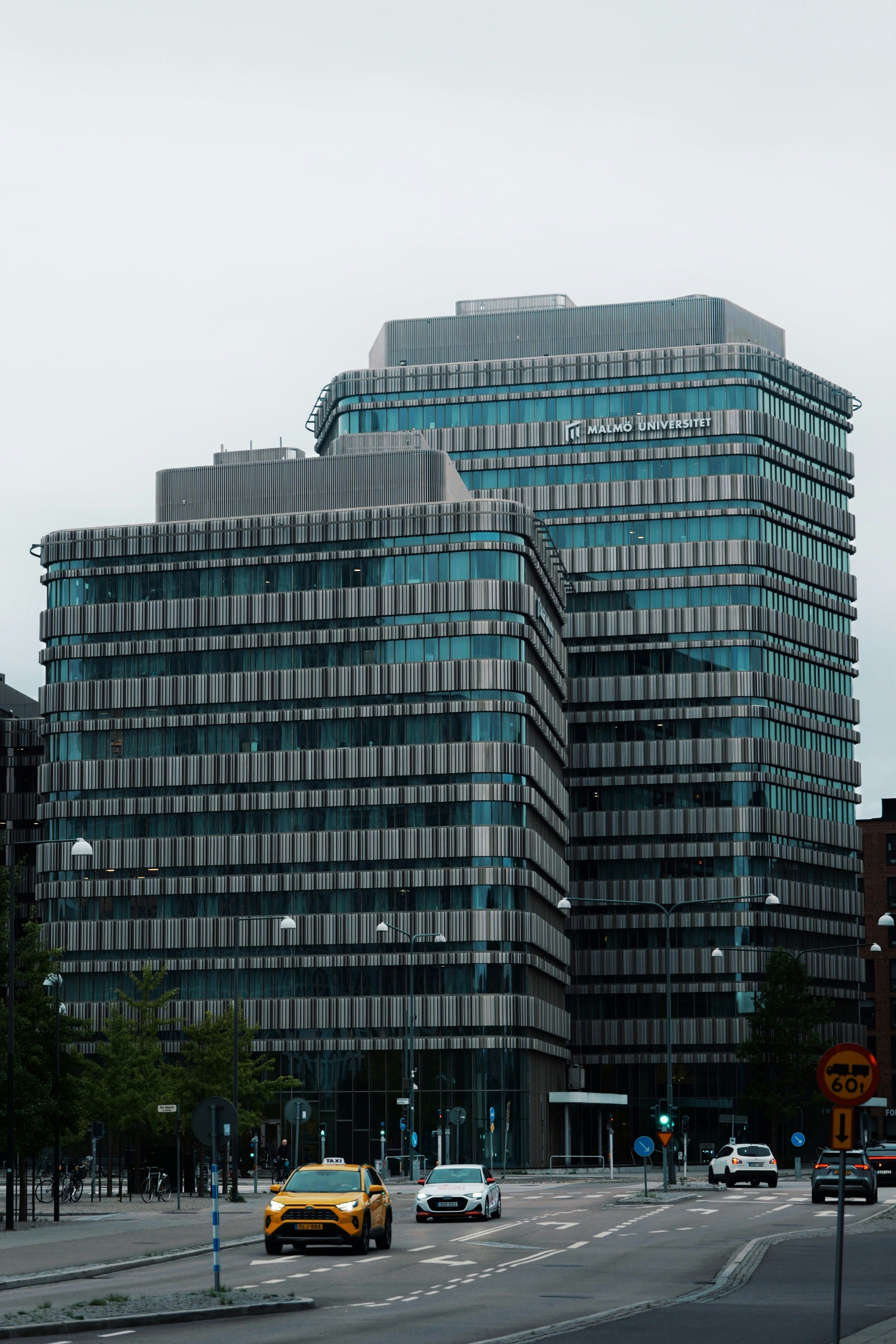 Modern glass office buildings with vertical slats in Malmö under a grey sky