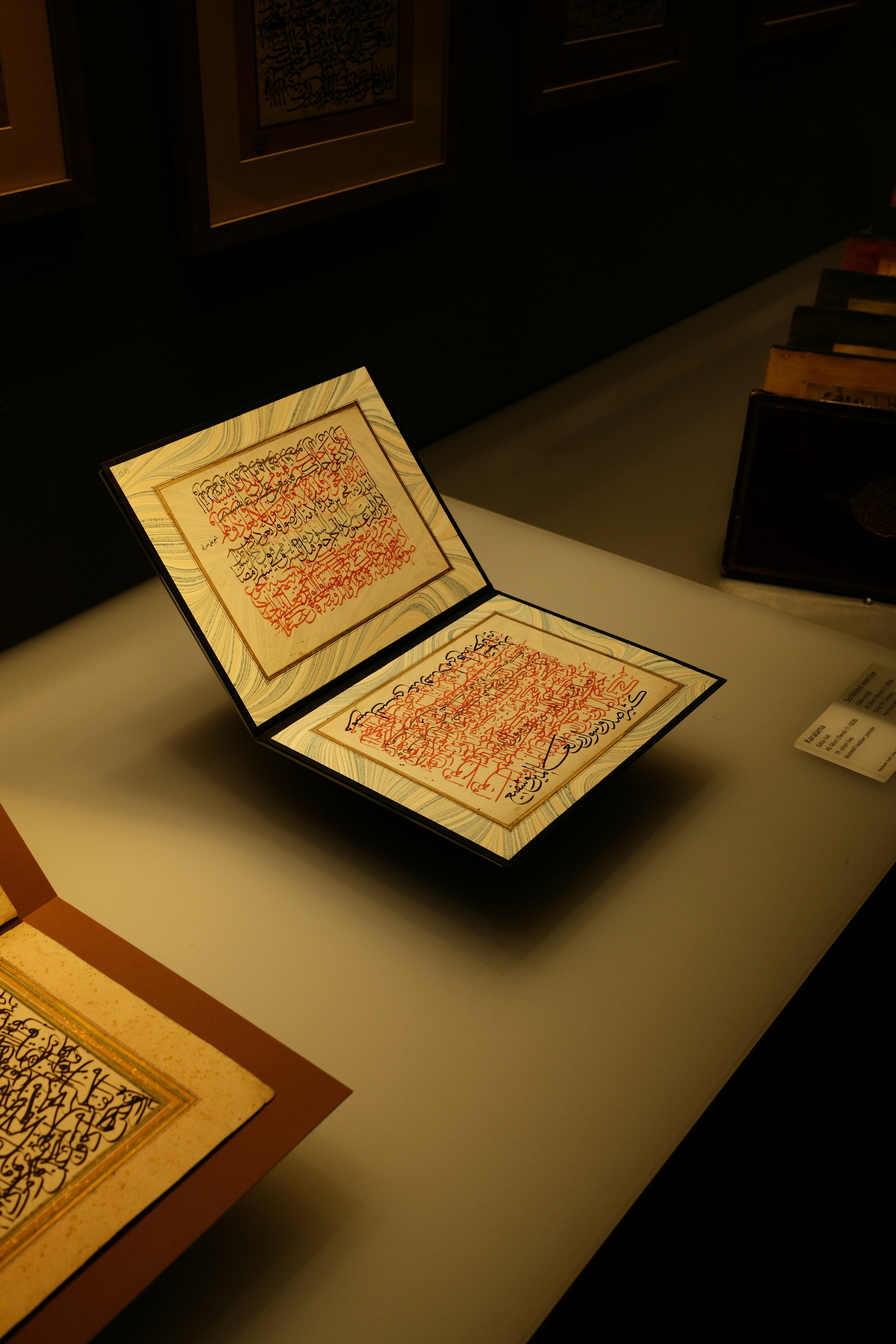Eine offene Handschrift mit kunstvoller rot-schwarzer arabischer Kalligraphie ist ausgestellt