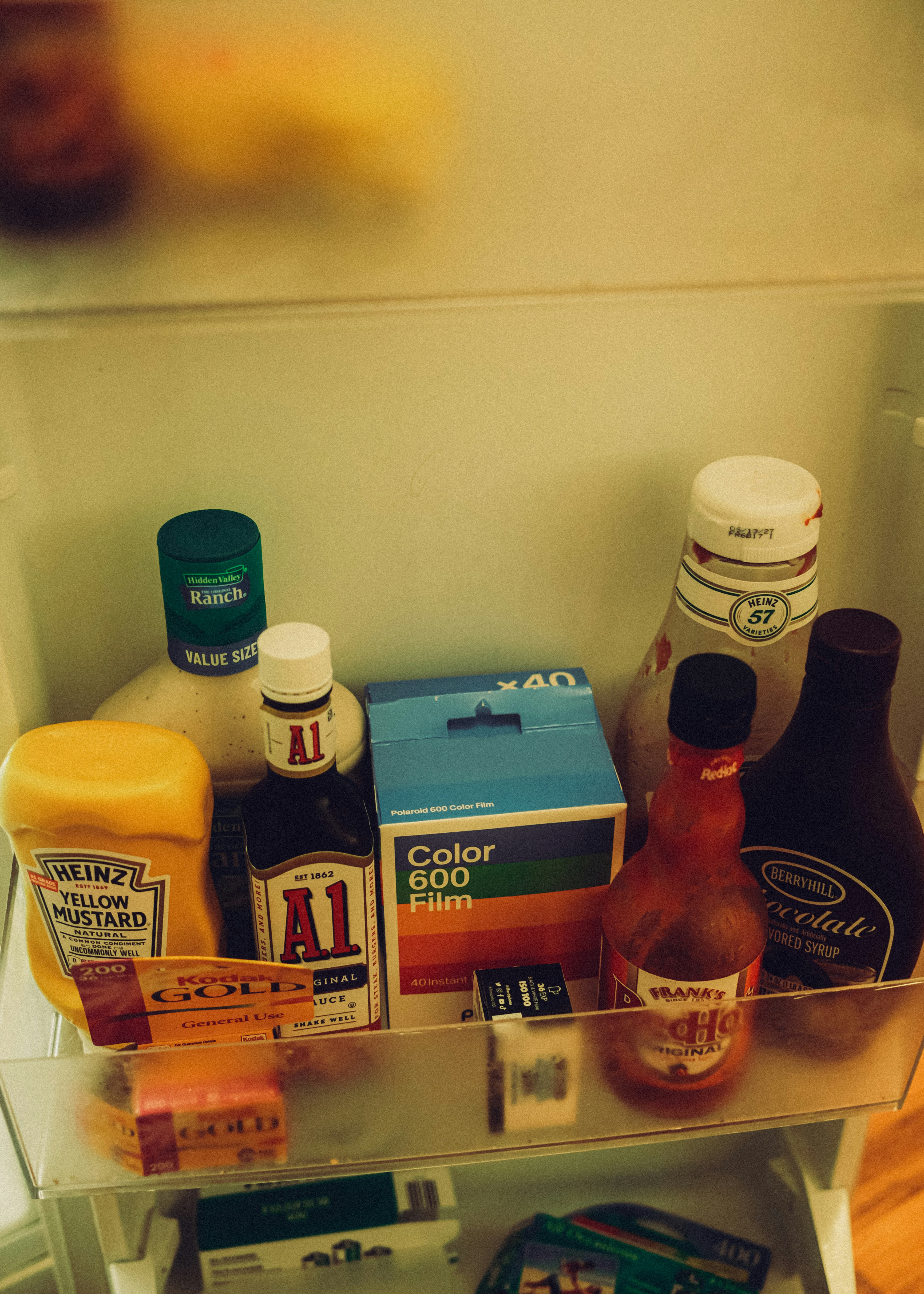 Condiments and boxes of film stored on a refrigerator door shelf