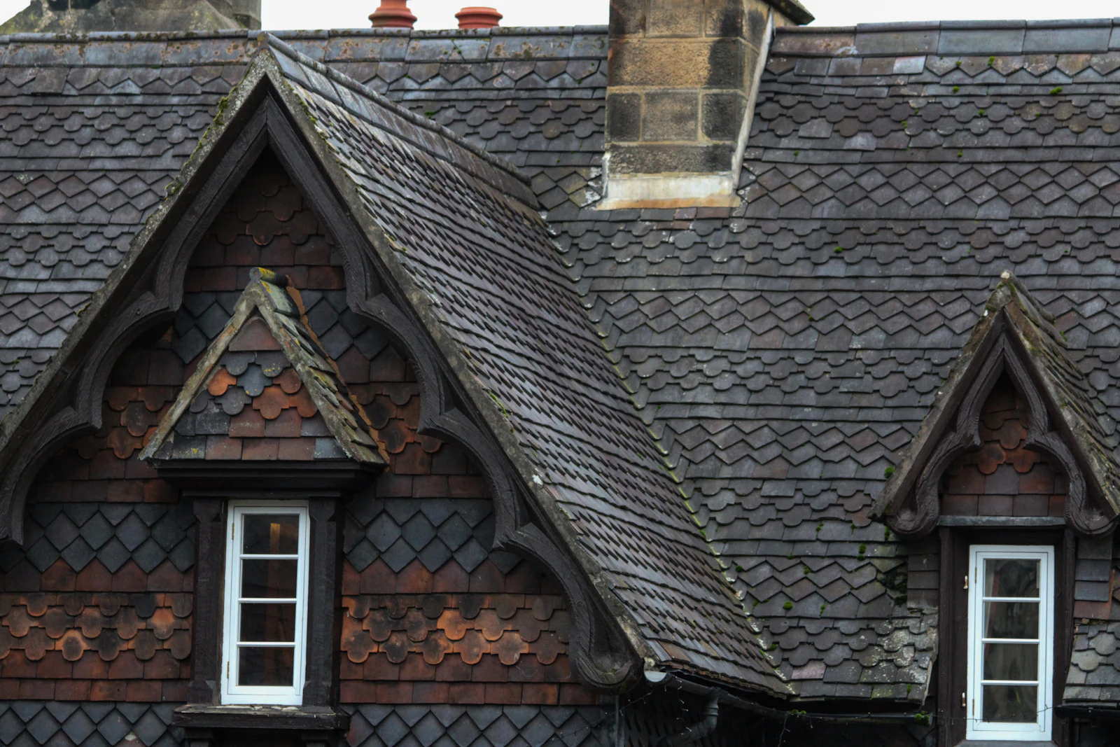Victorian slate roof with gabled dormer windows and decorative fish-scale slates