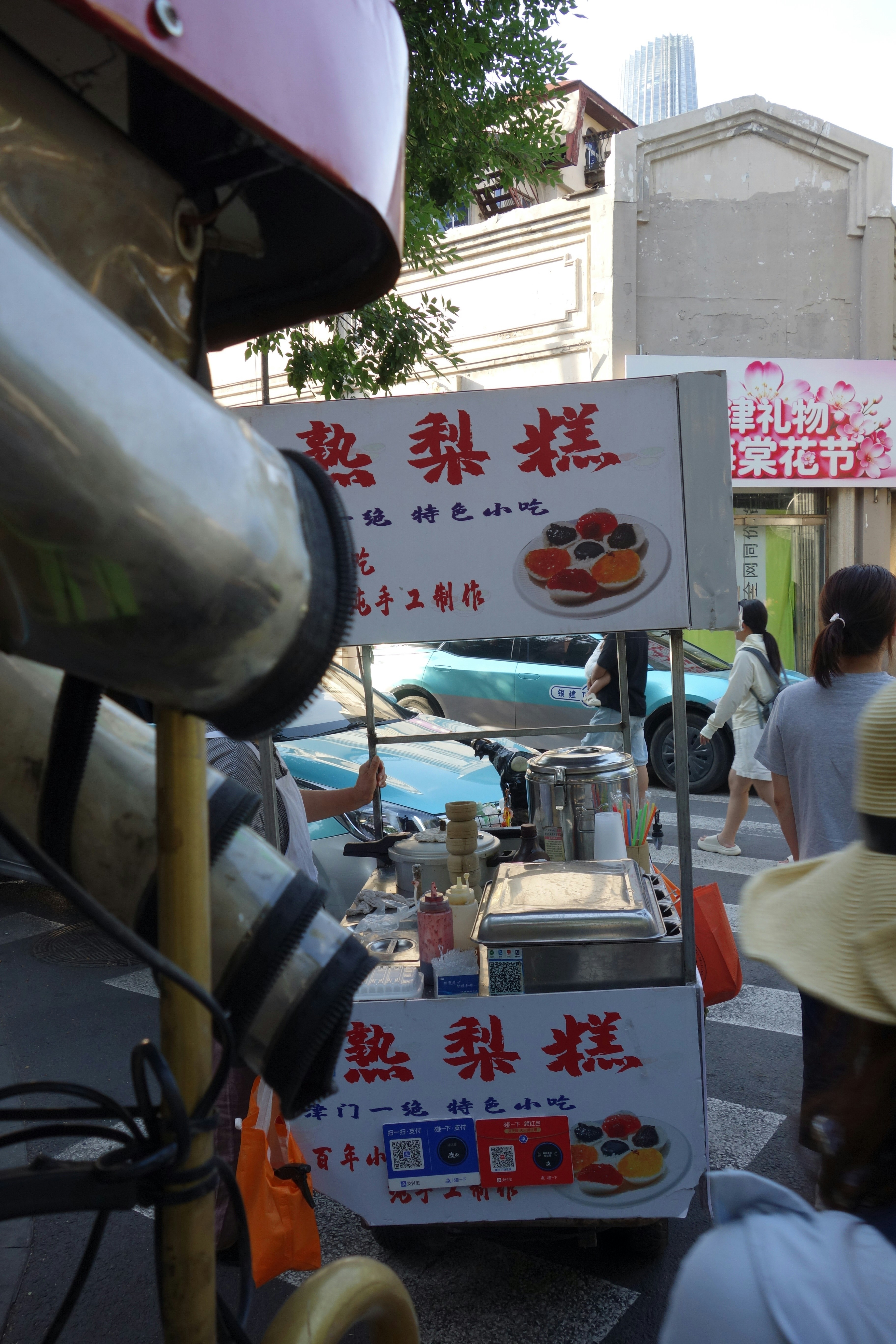 Un carrello di street food che vende snack tradizionali su un marciapiede affollato della città