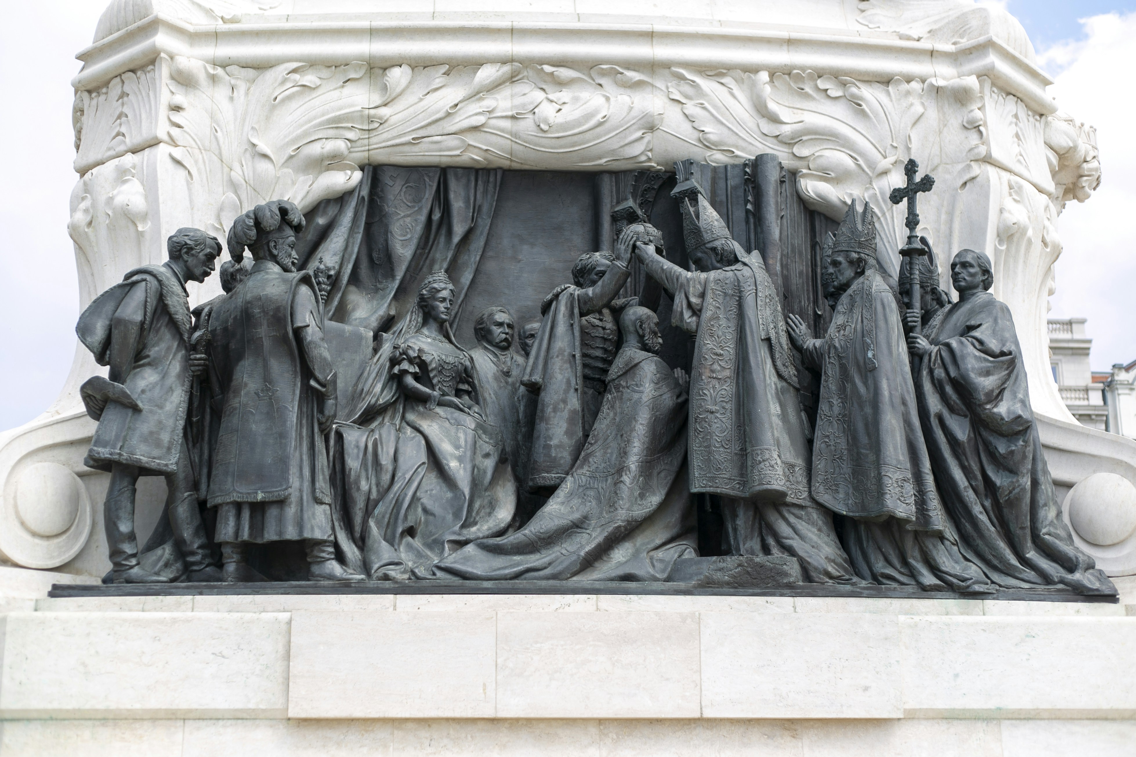 Bronze relief sculpture of a royal coronation ceremony with figures in historical attire