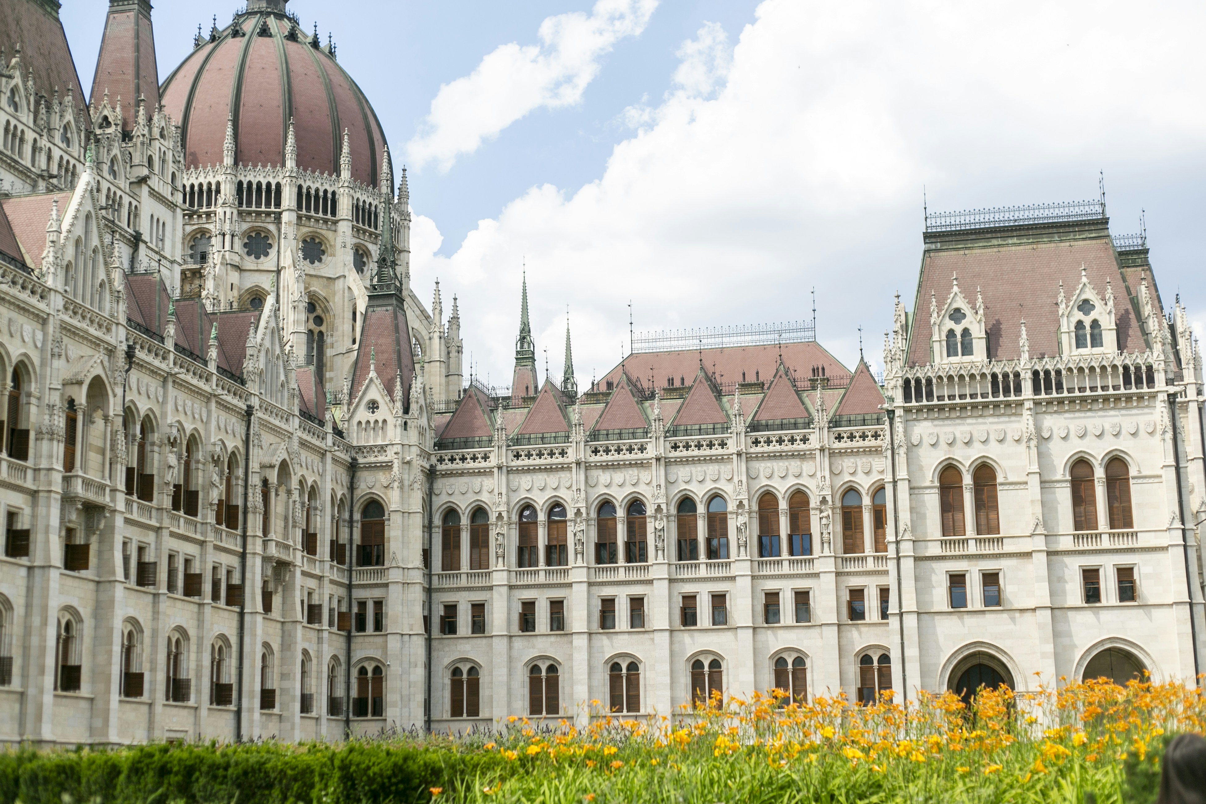 The Hungarian Parliament Building in Budapest with orange daylilies in the foreground