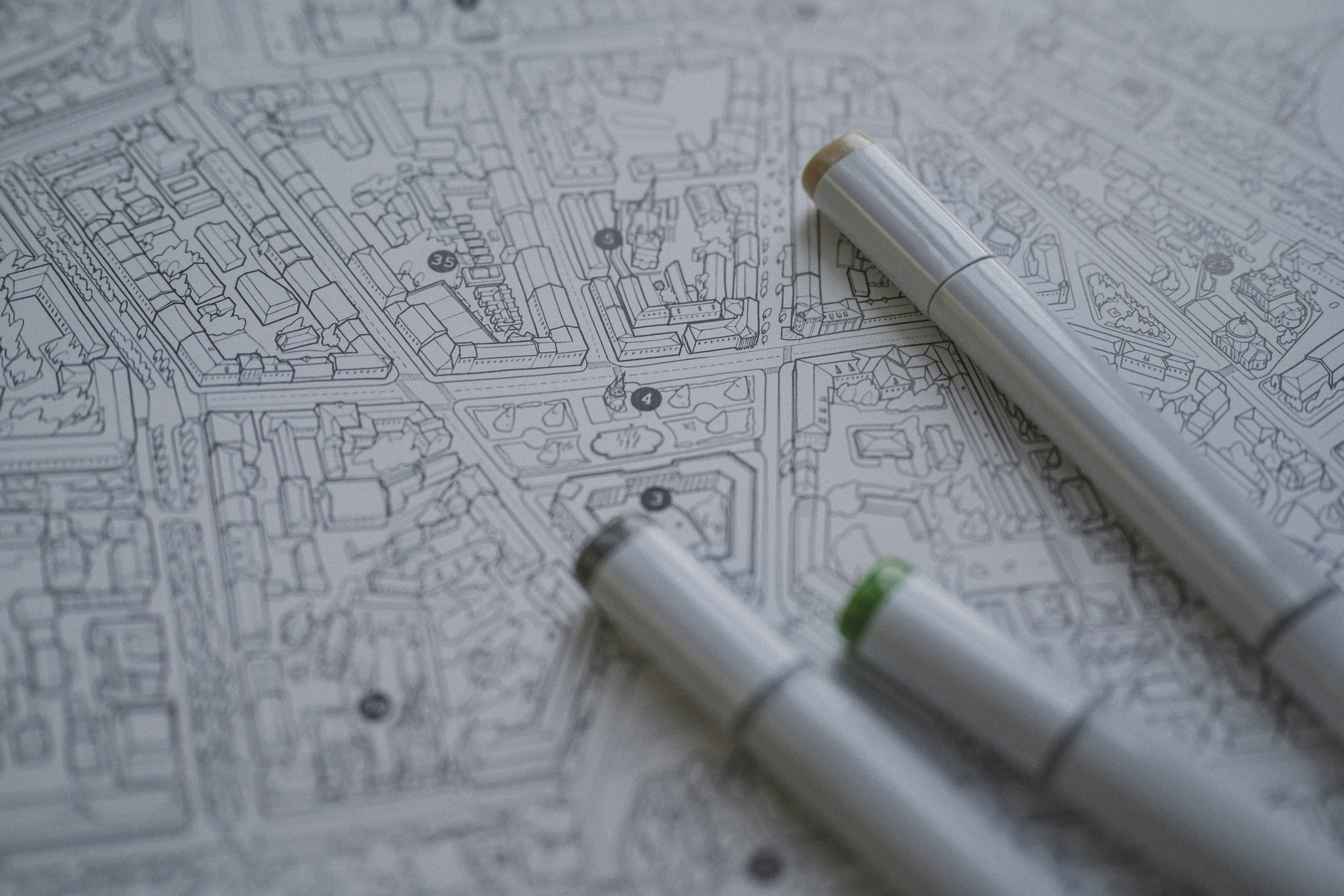 Three markers resting on a detailed black and white city map