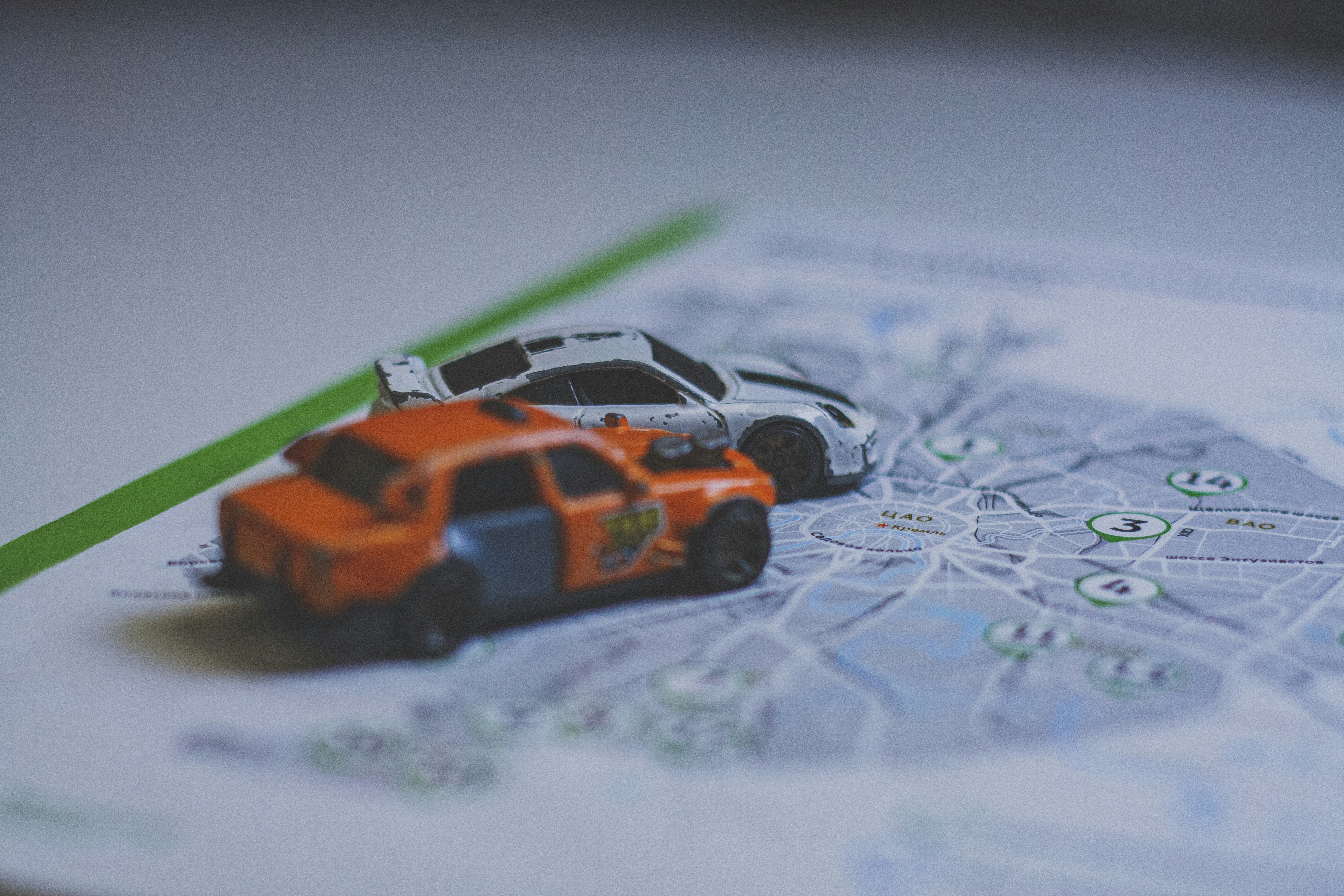 Two toy cars on a printed map of Moscow city streets