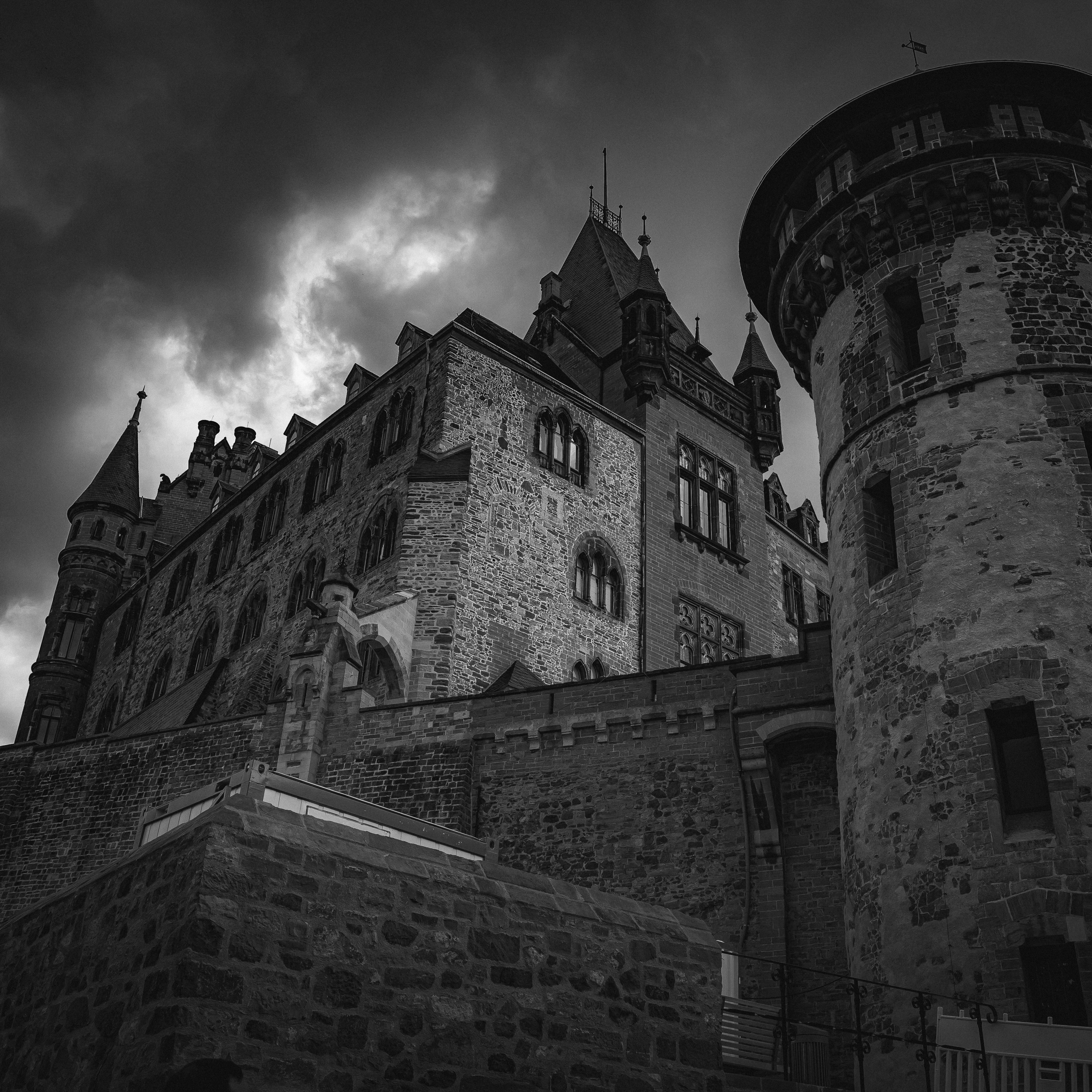 A stone castle with tall towers under a dark and cloudy sky