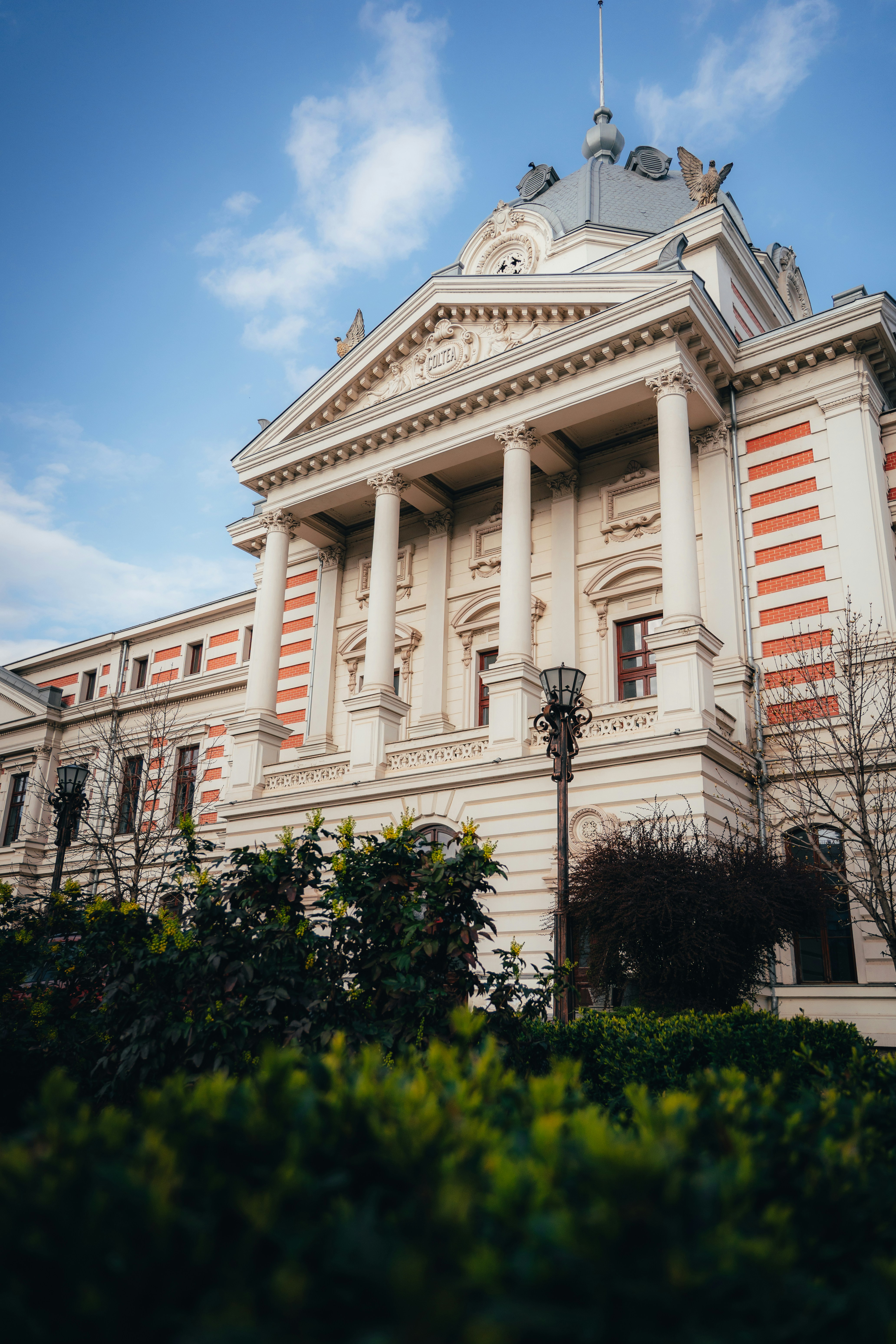 The Coltea Hospital building with neoclassical columns and red brick accents in Bucharest