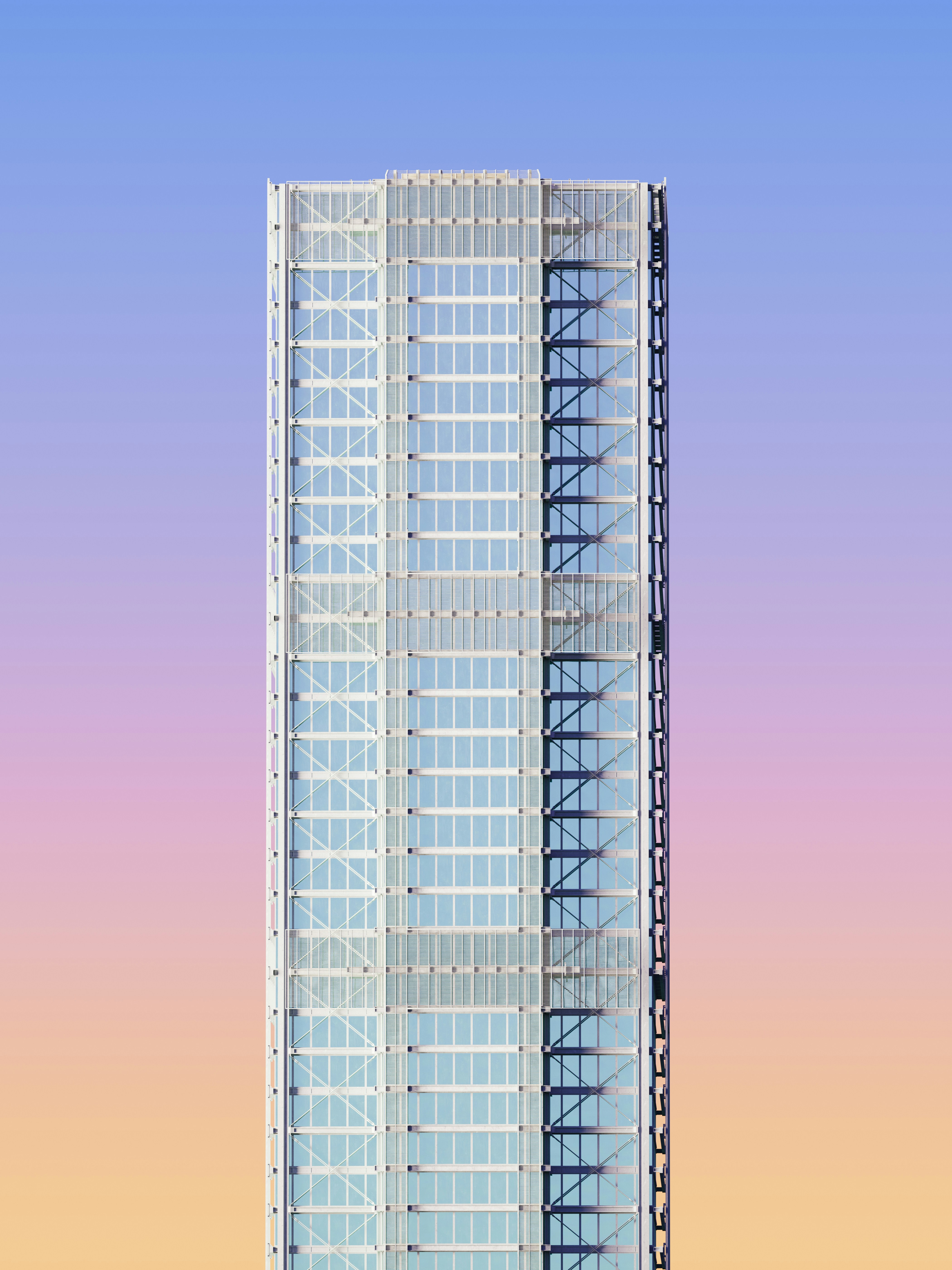 A modern glass skyscraper against a gradient sky shifting from blue to orange