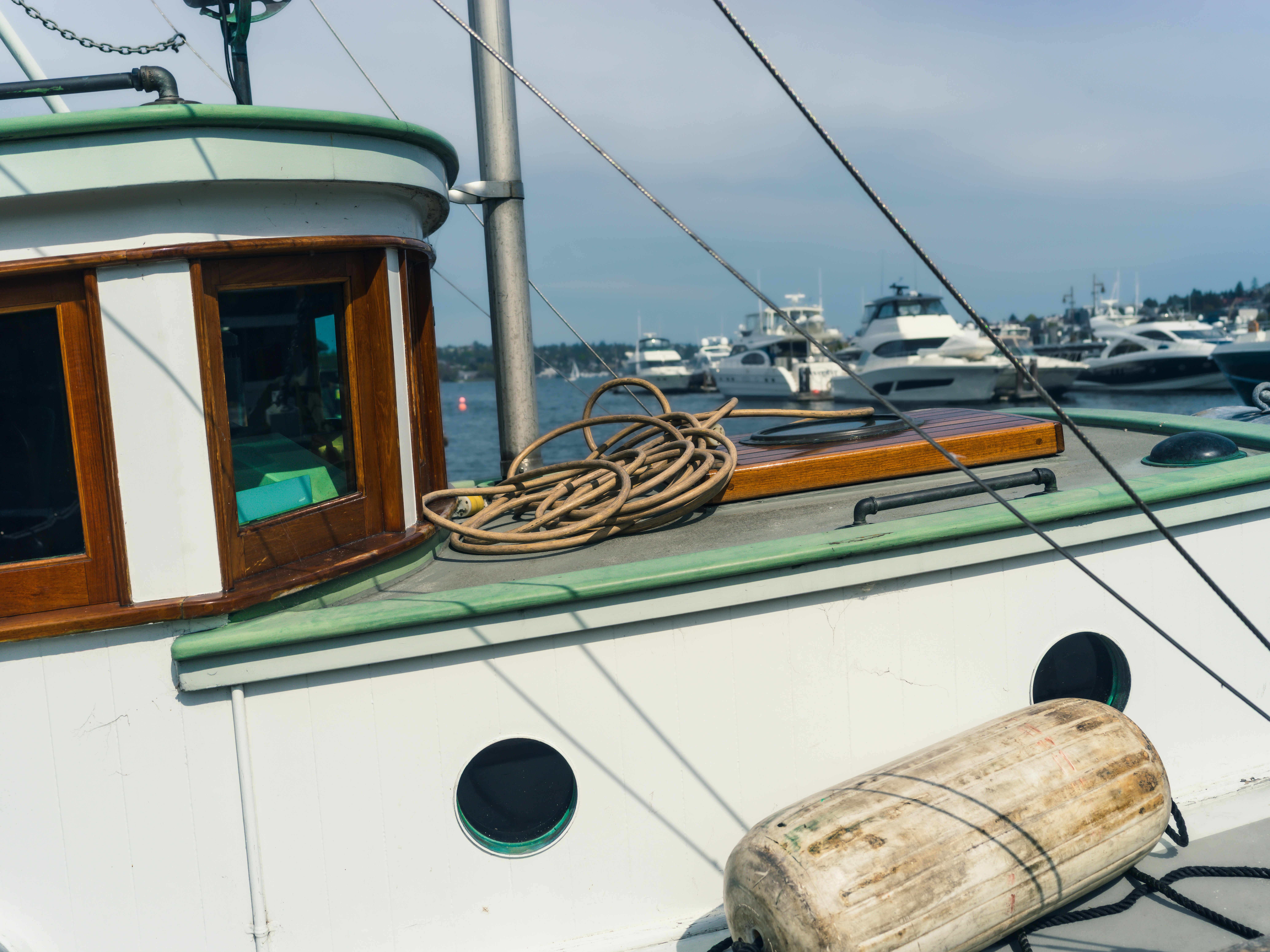 A coiled rope on the deck of a white boat with green trim