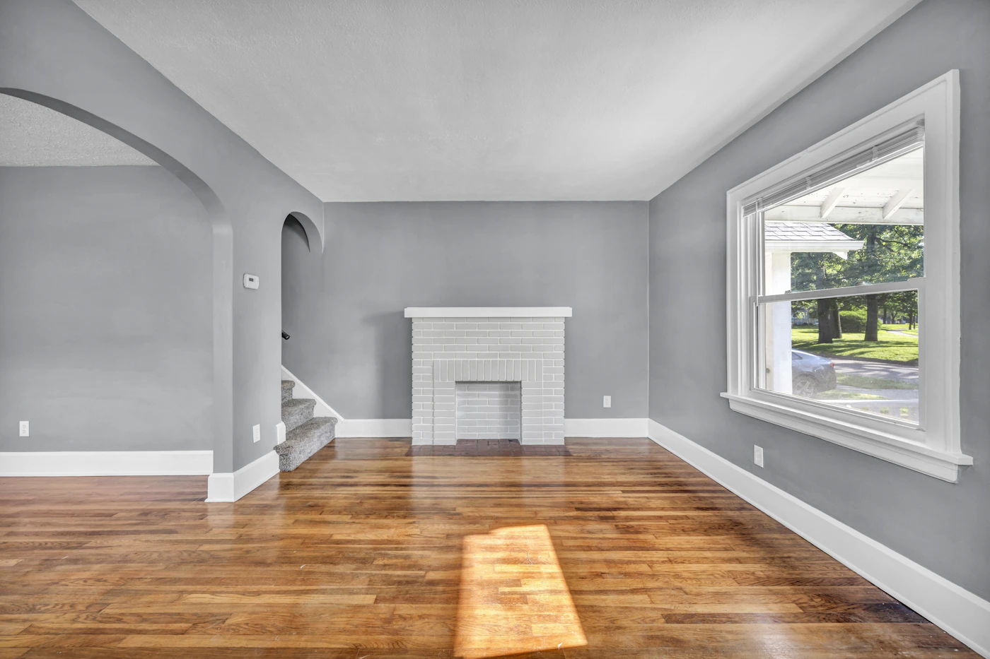 A sunlit renovated living room with natural wood floors