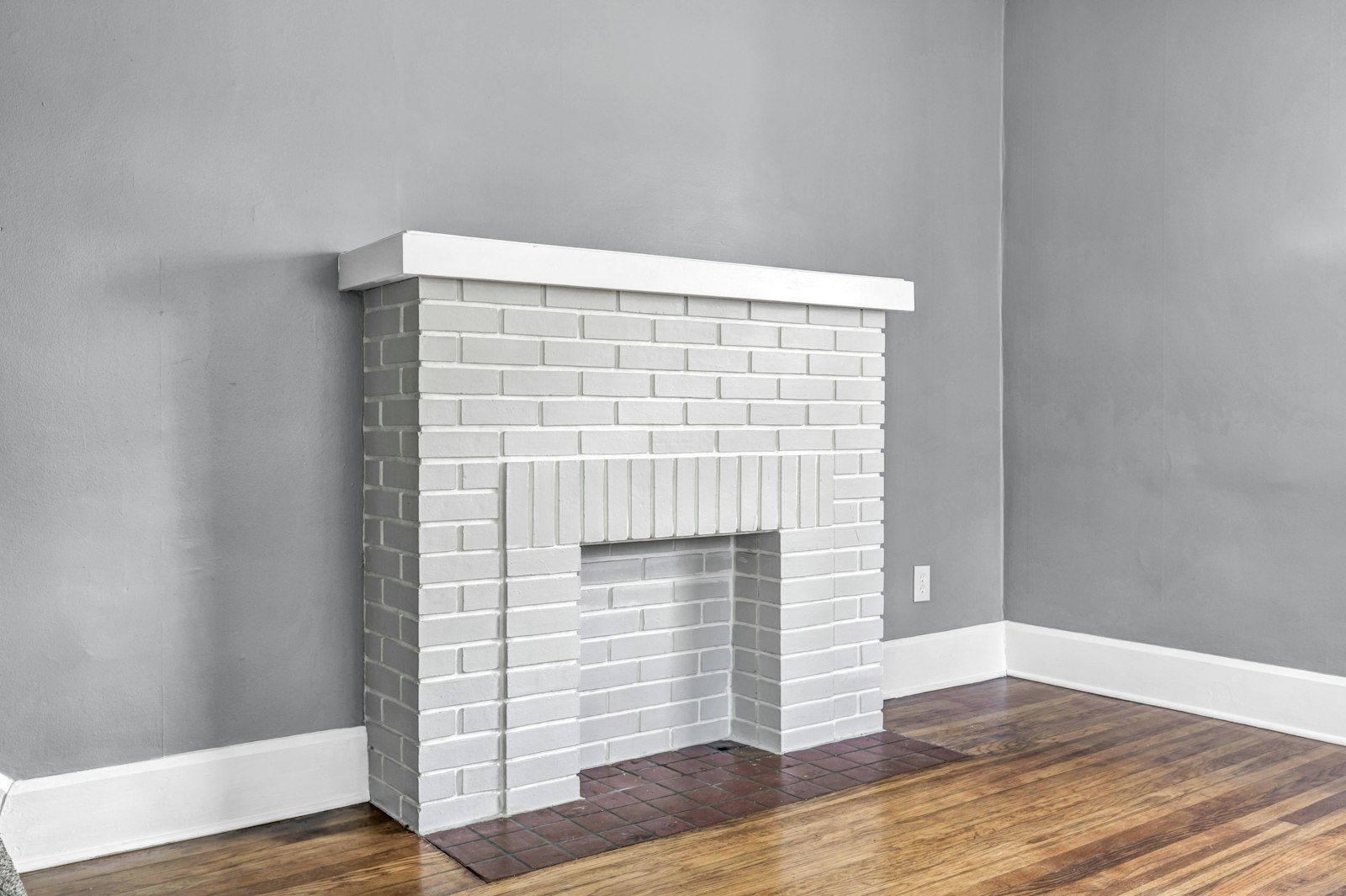Empty living room with a white brick fireplace