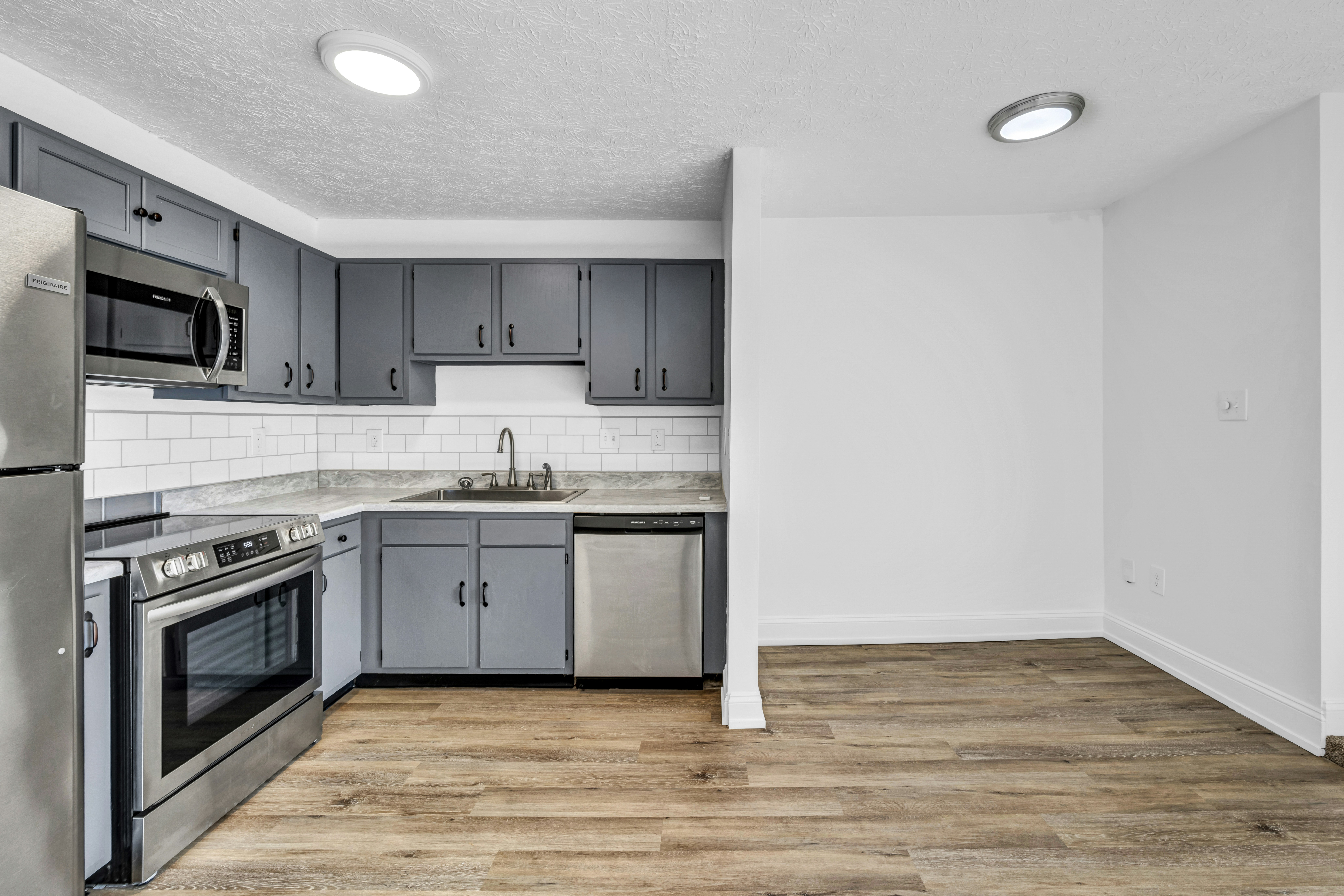 Empty apartment kitchen with grey cabinets