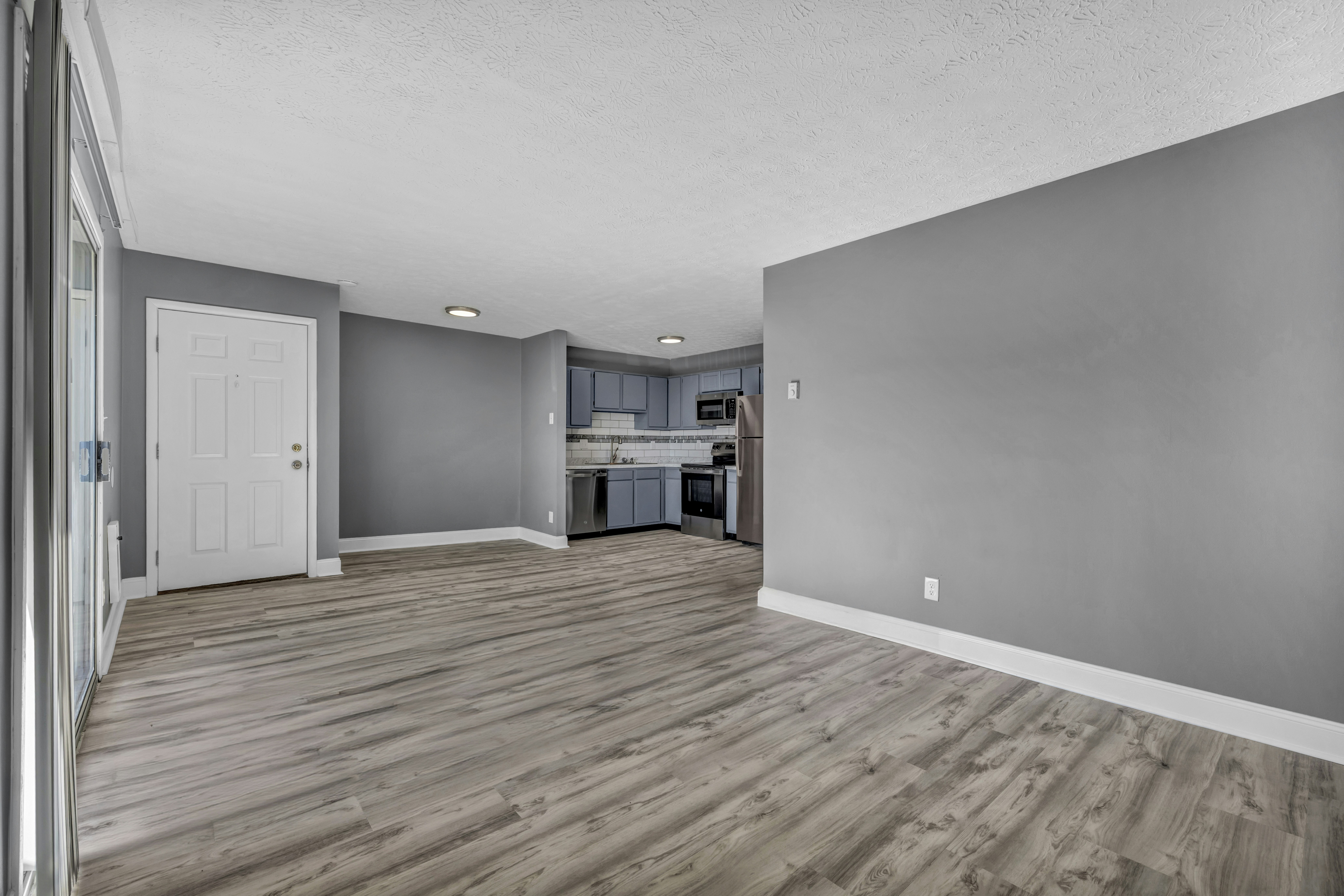 An empty living area with light wood floors, ready for move-in