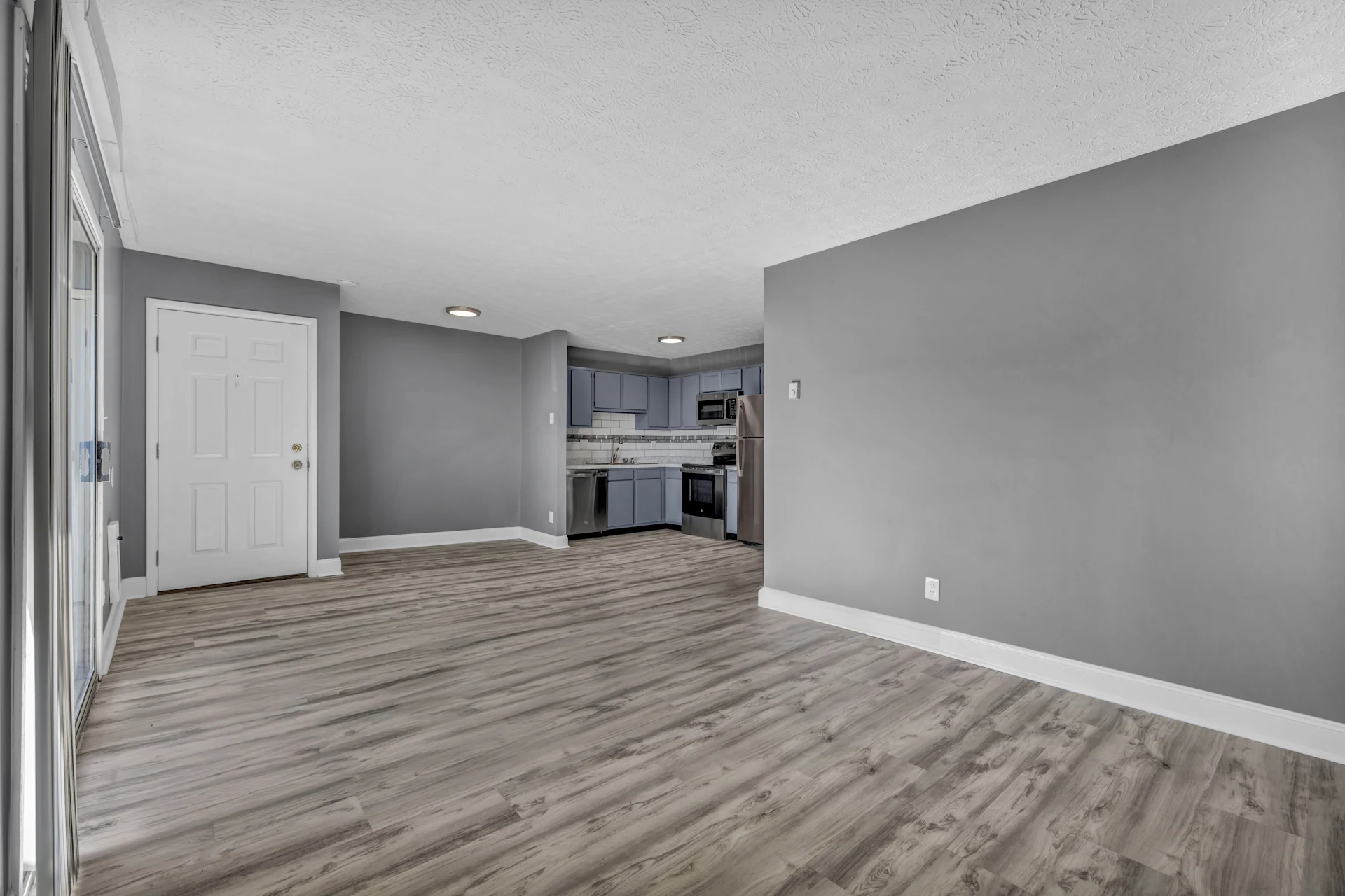 Empty apartment with grey walls and a light wood floor