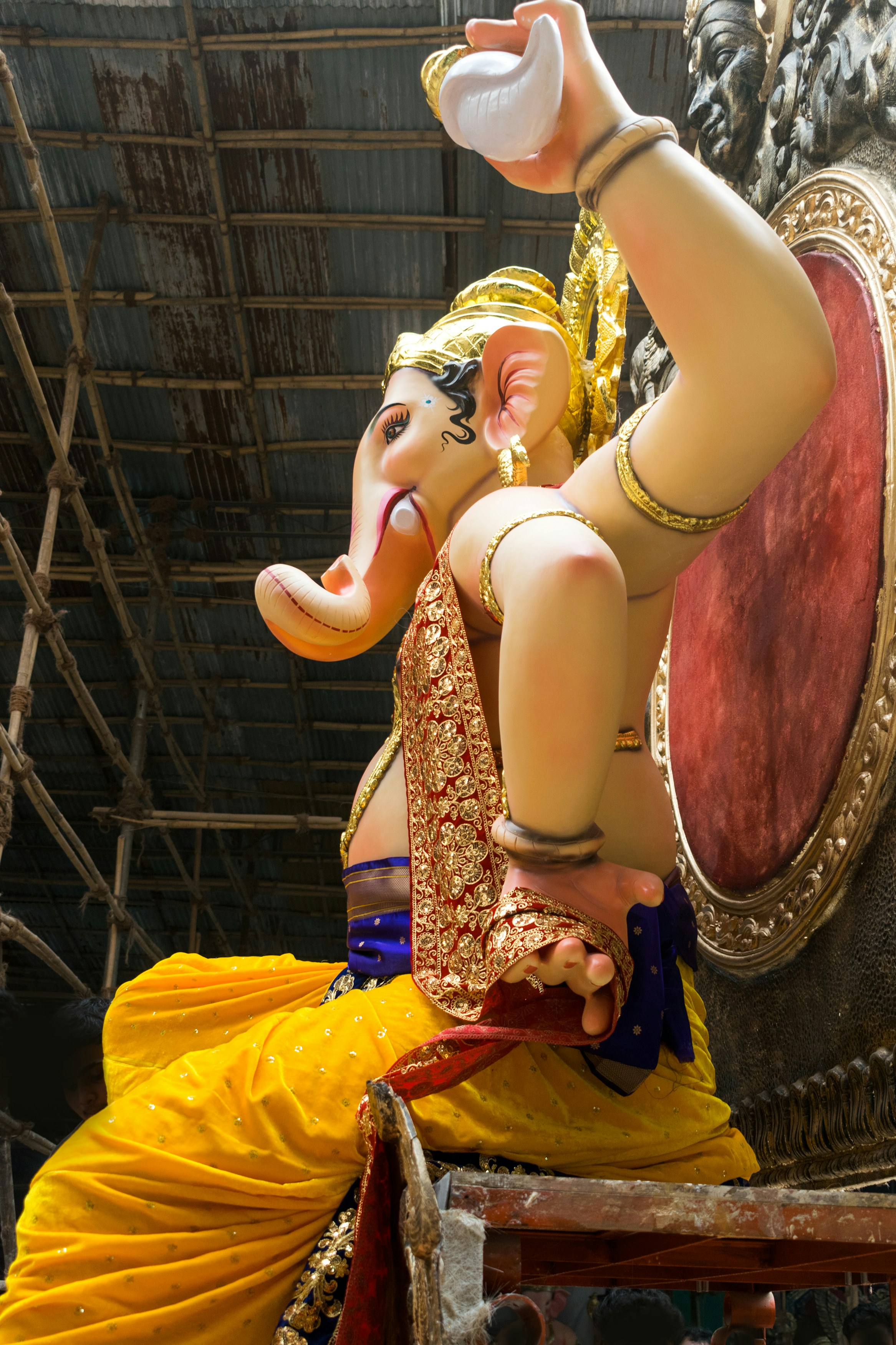A large statue of Lord Ganesha in yellow robes in Mumbai, India