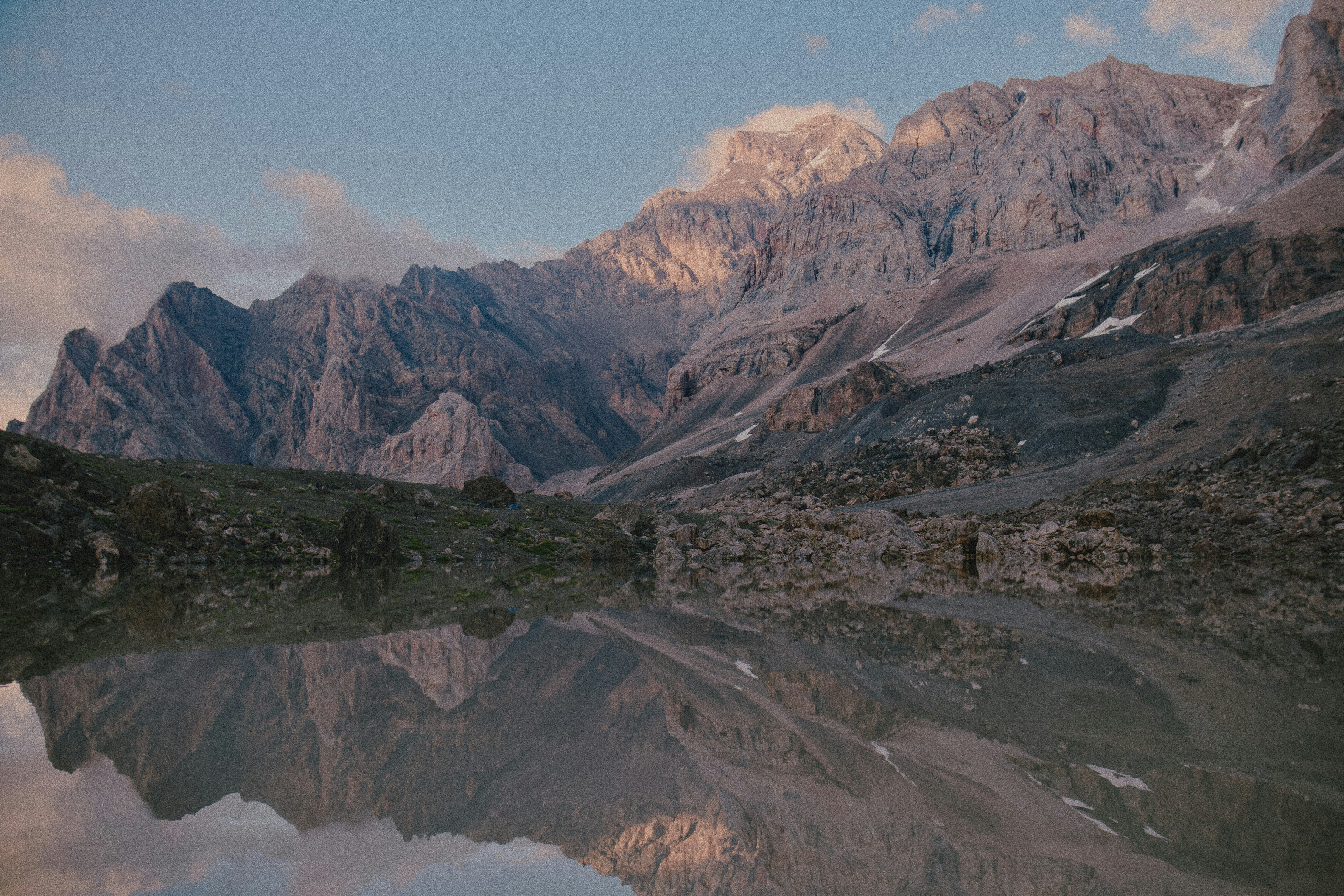 Rugged mountain peaks reflected in the calm water of a high alpine lake