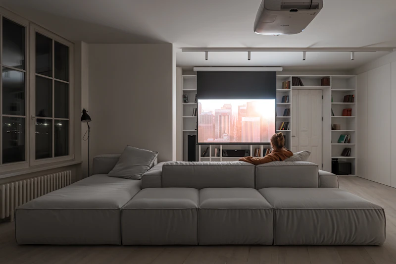 A person on a large sofa watching a projected movie