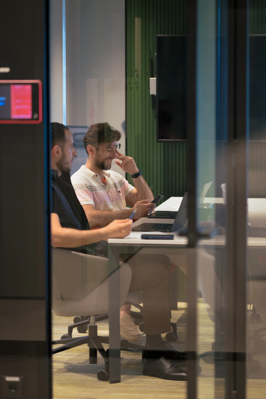 Two colleagues working in a glass-walled office