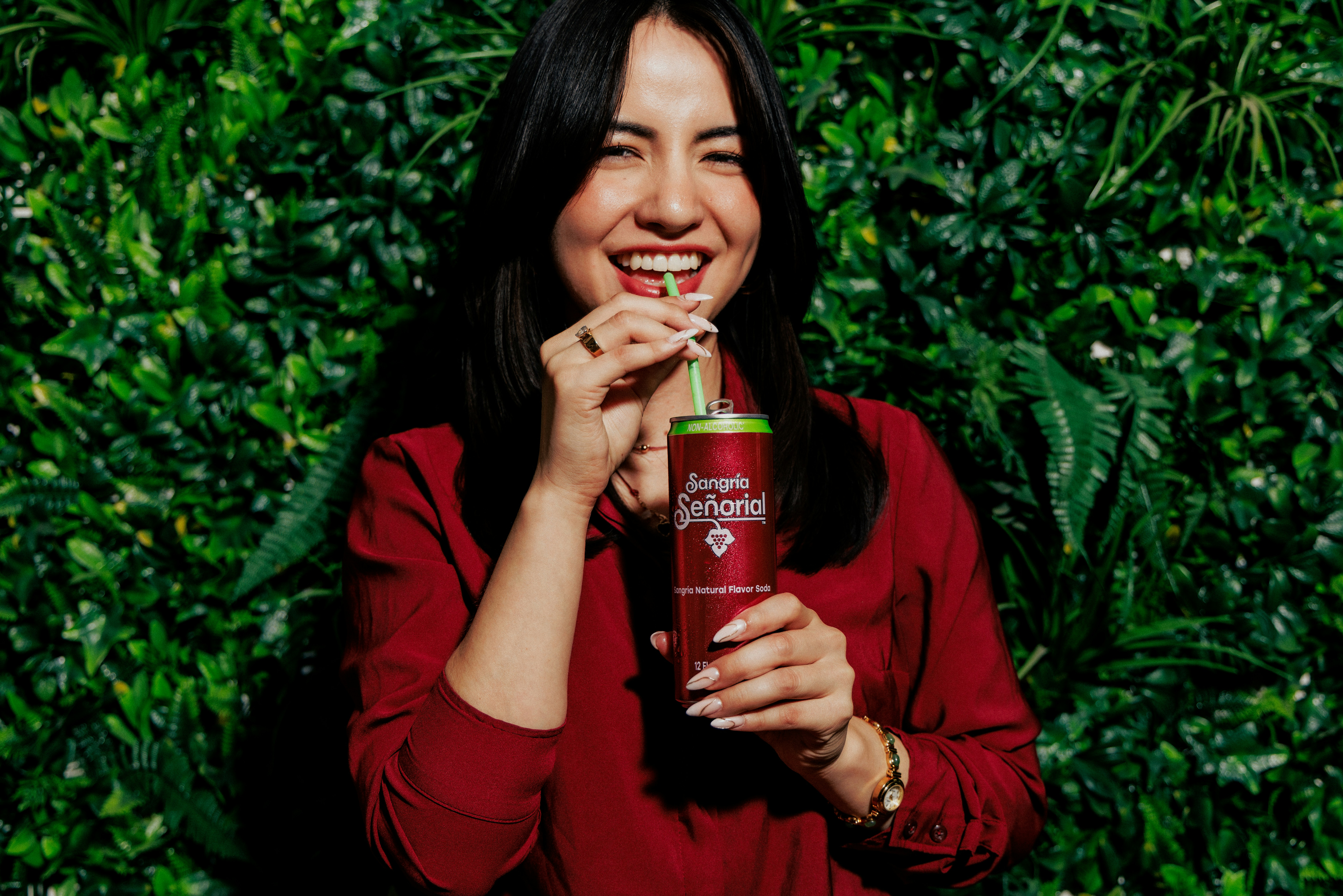 A woman in a red shirt drinking from a can of Sangria Señorial
