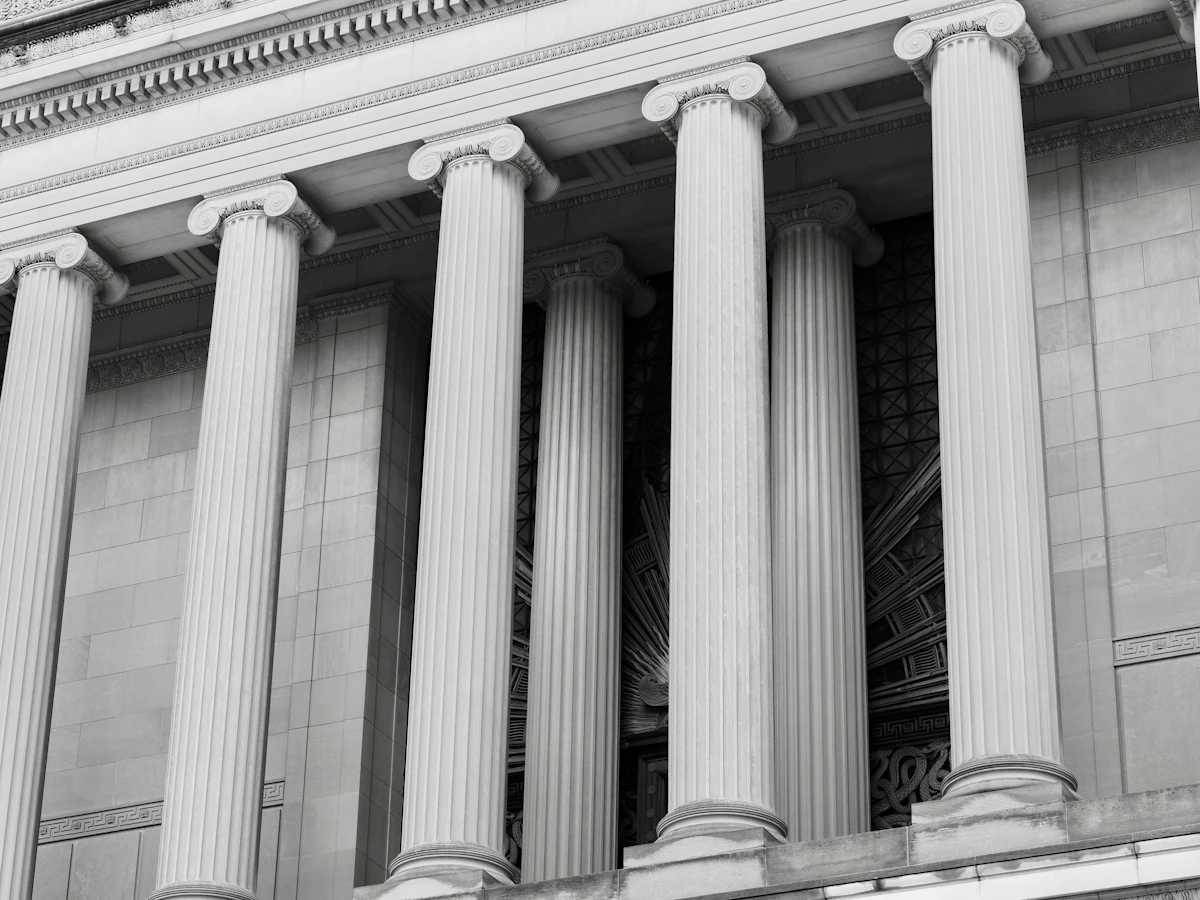 Fluted stone columns with ionic capitals on a classical facade, in black and white