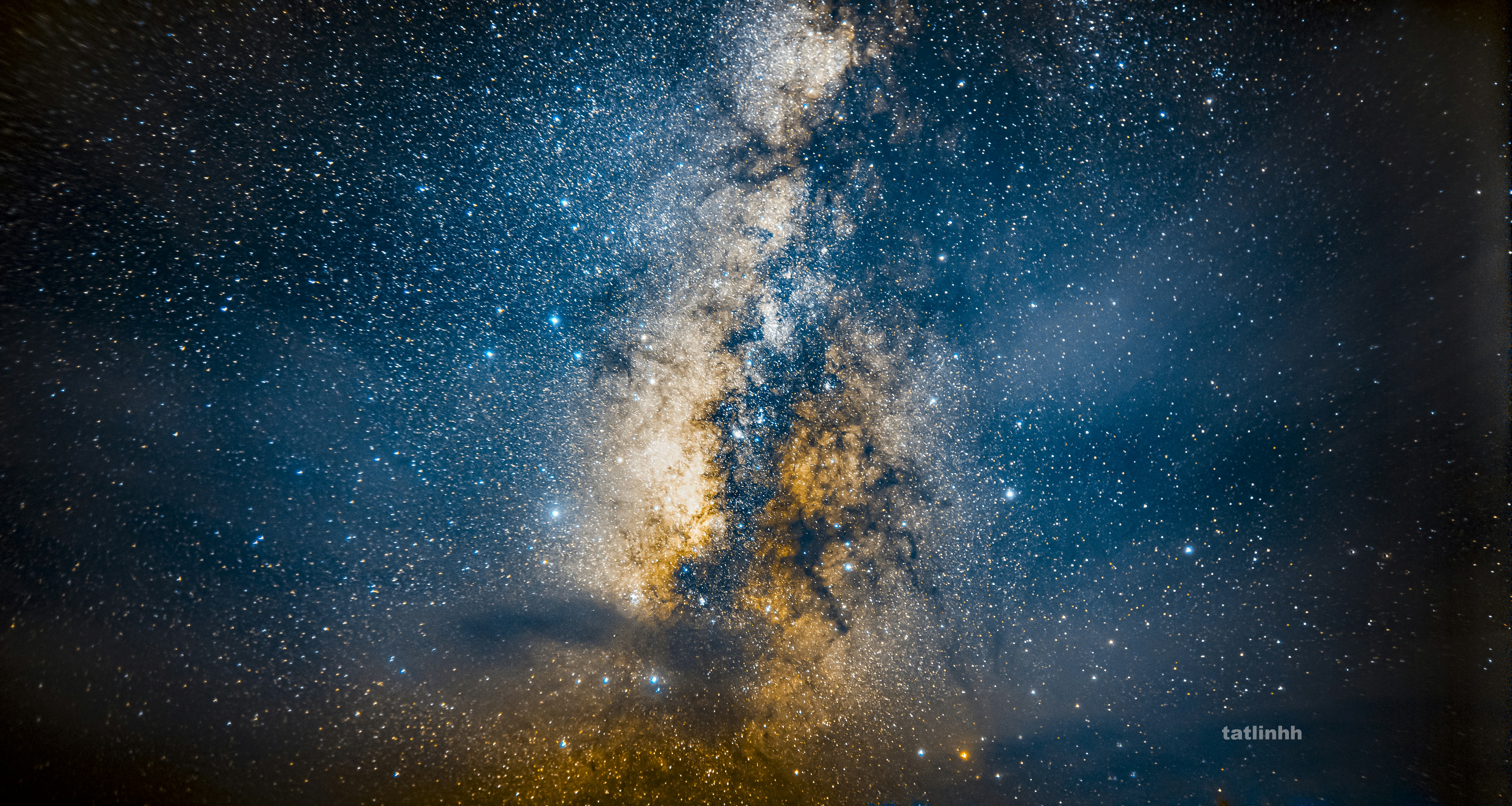 The Milky Way galaxy glowing with dense stars and golden dust clouds