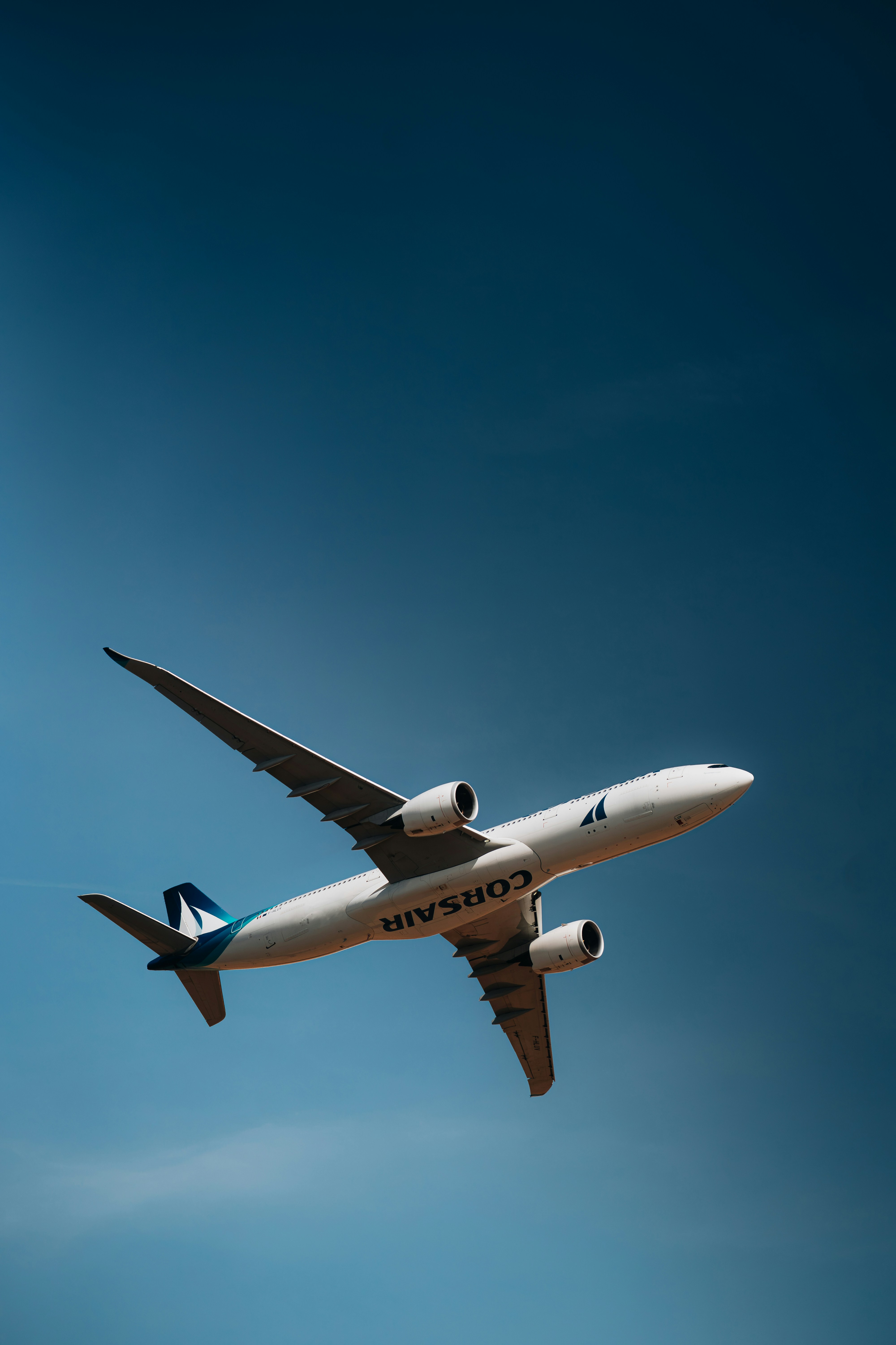Ein weißes Corsair-Passagierflugzeug fliegt durch einen klaren blauen Himmel
