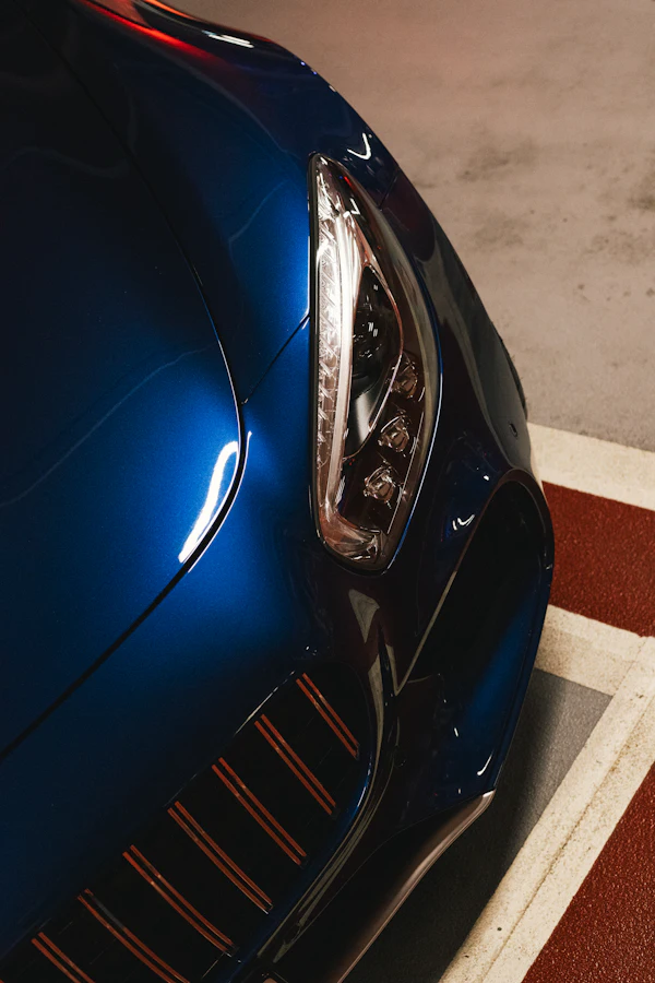 A close-up of a clean blue car headlight and hood