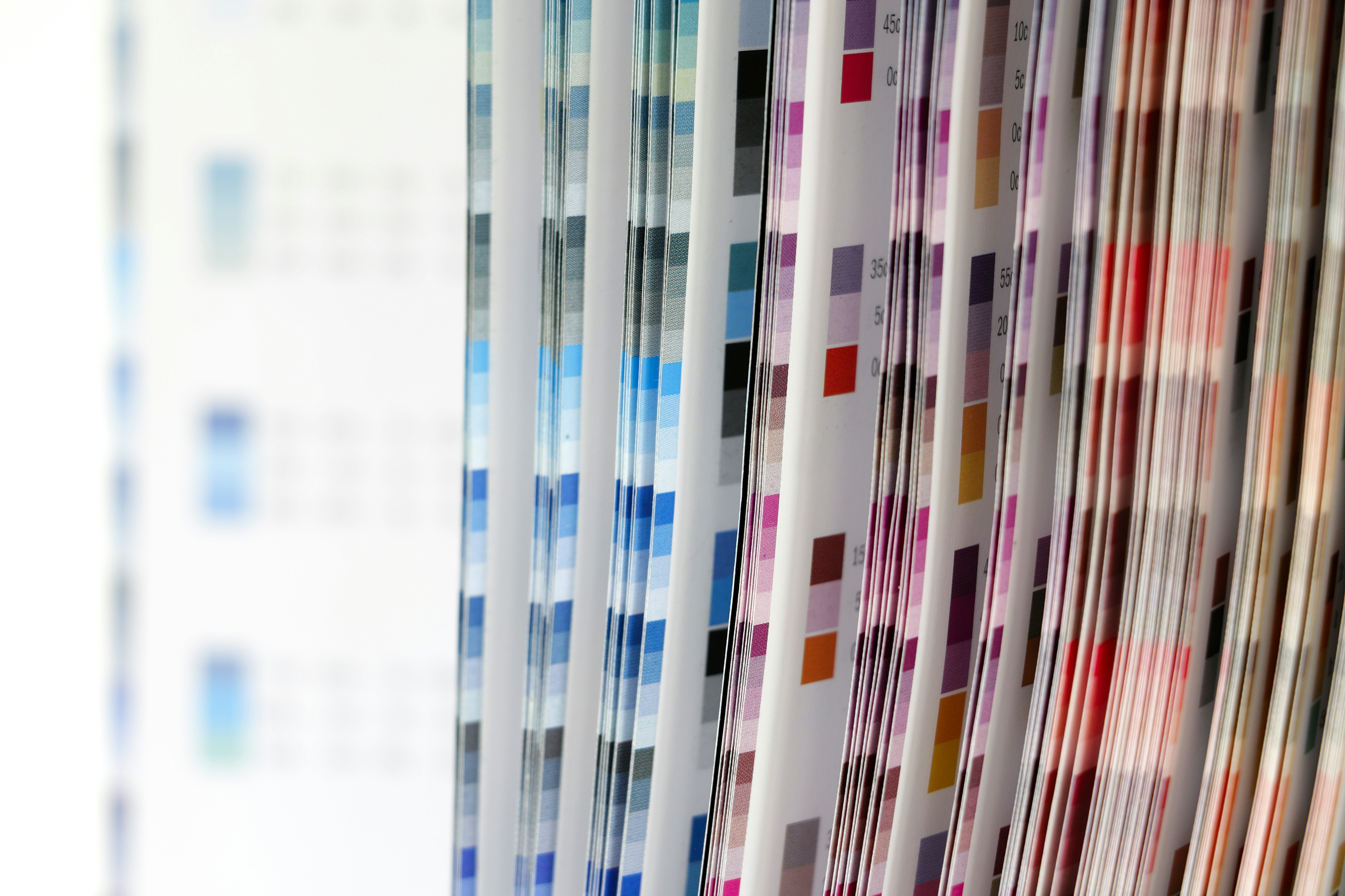A color swatch book with pages of printed color grids and percentage values