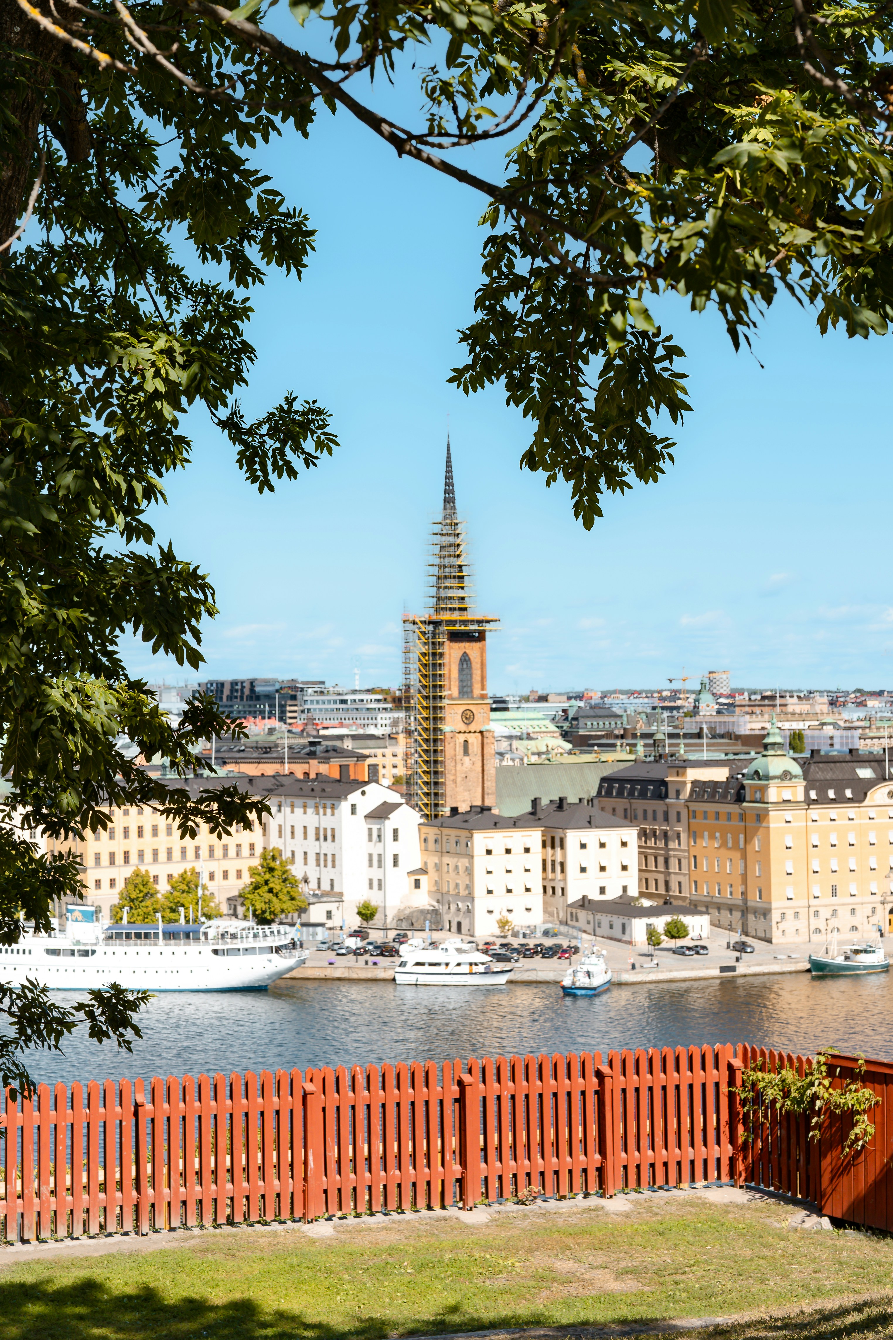 The Riddarholmen Church tower with scaffolding overlooking the Stockholm waterfront and city buildings