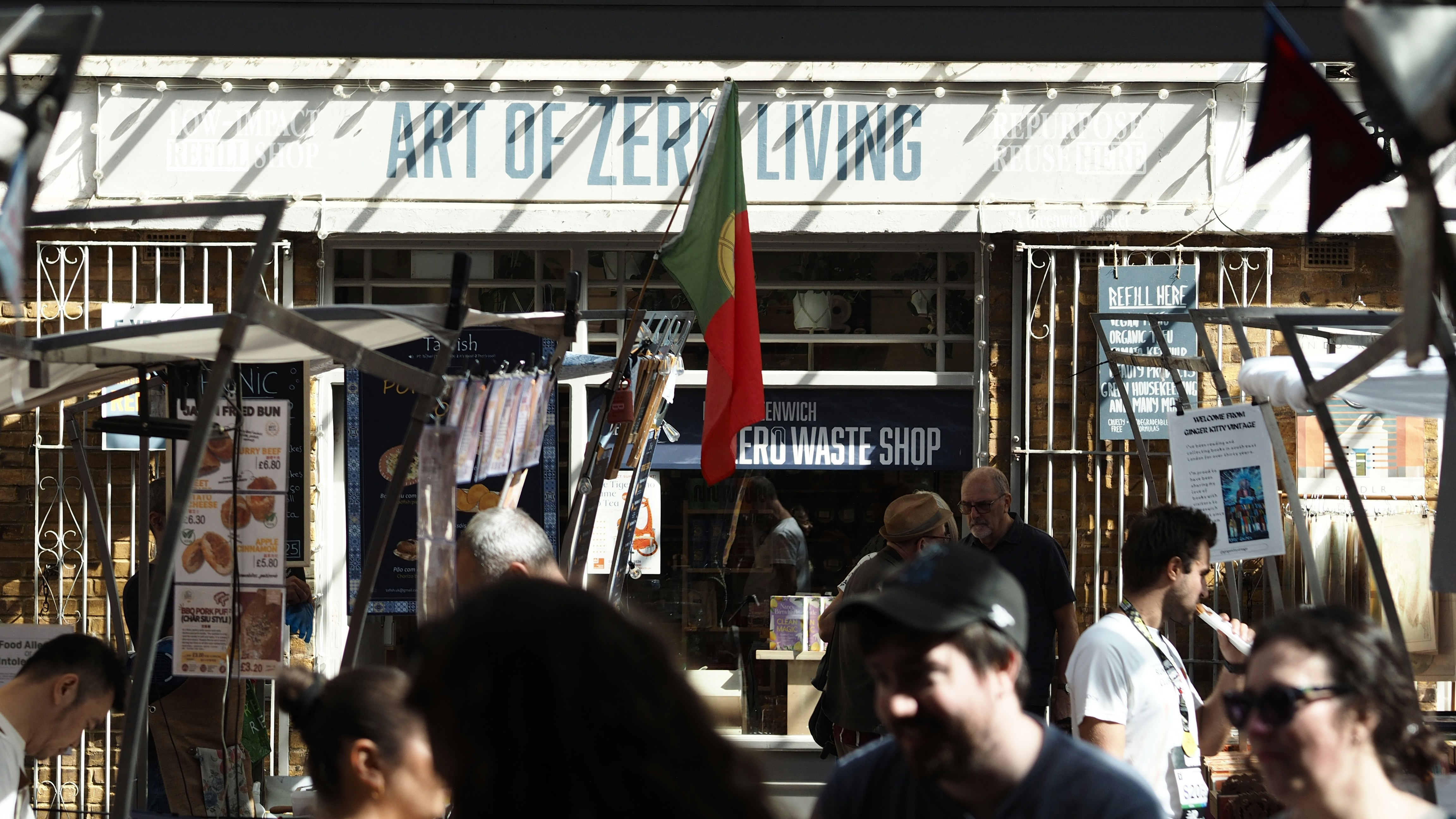 People browsing a zero waste shop at a busy outdoor market in London
