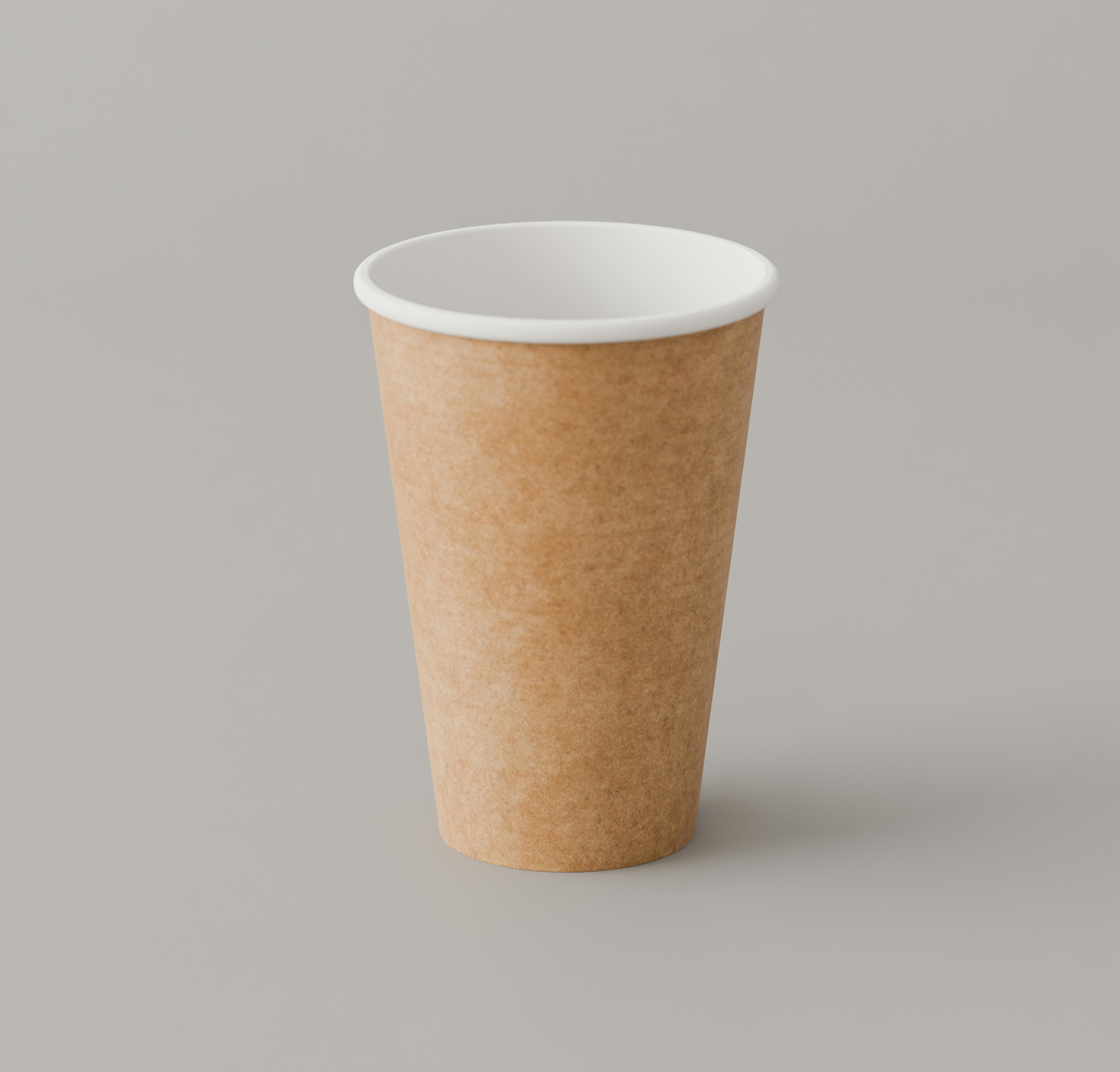 A brown paper coffee cup with a white rim on a grey surface