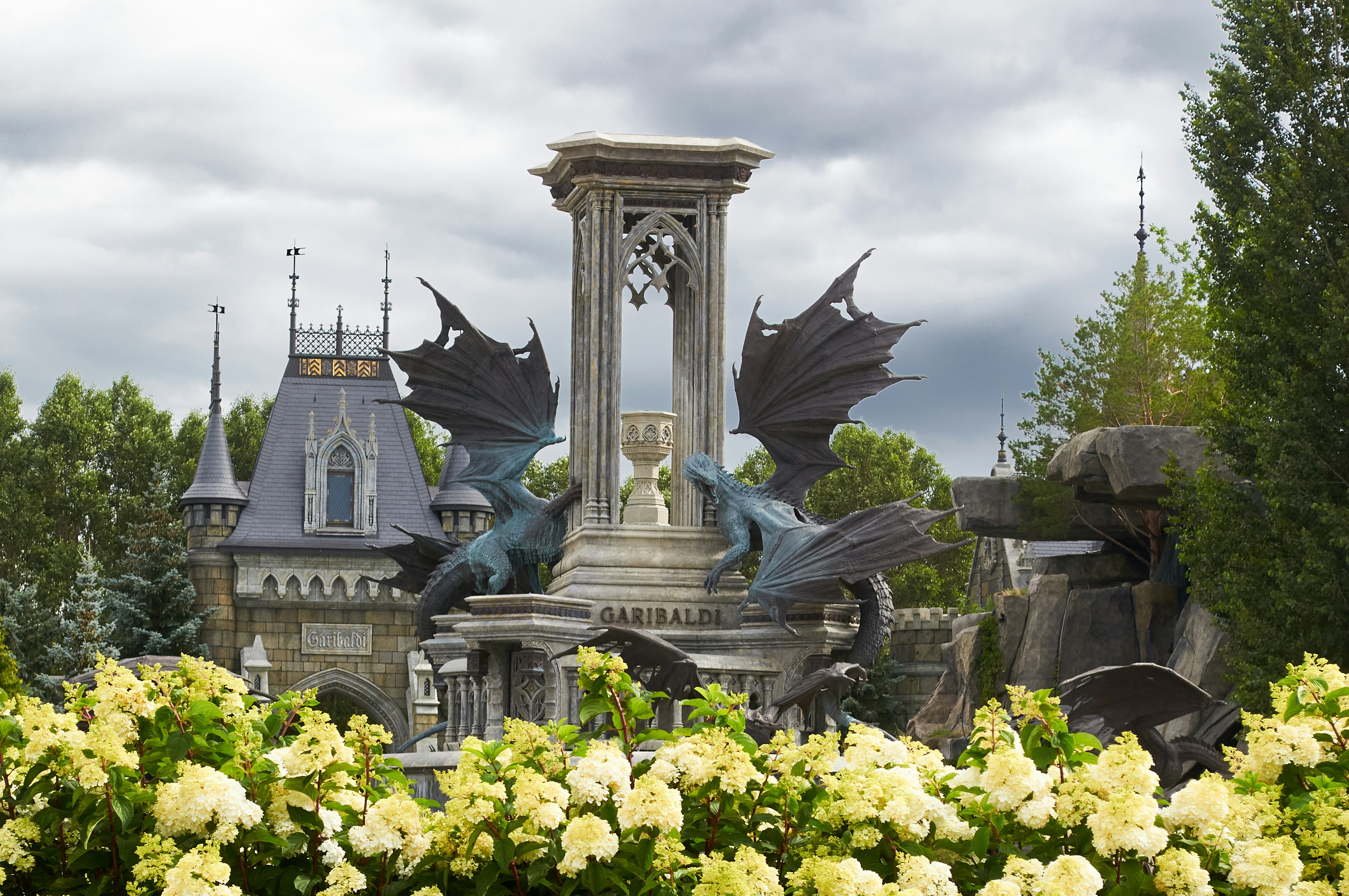 Bronze dragon statues on a stone fountain before a castle with Garibaldi signage