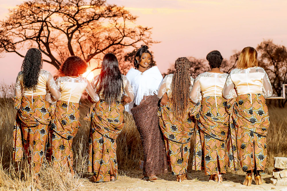 A family delegation in matching outfits walking towards an acacia tree at sunset