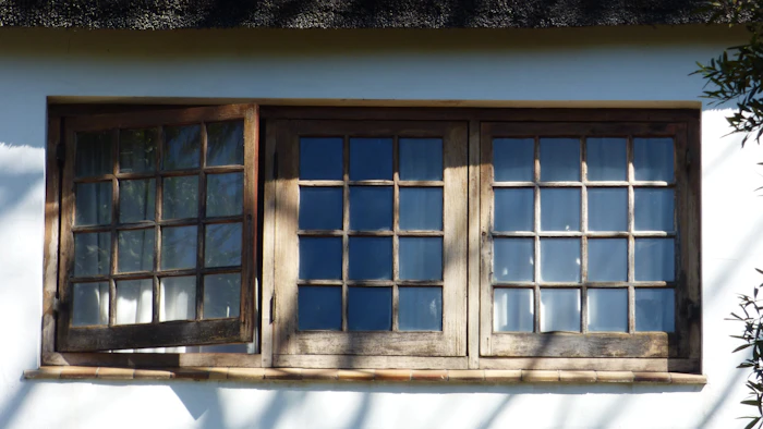 Wooden window with several panes on a white wall