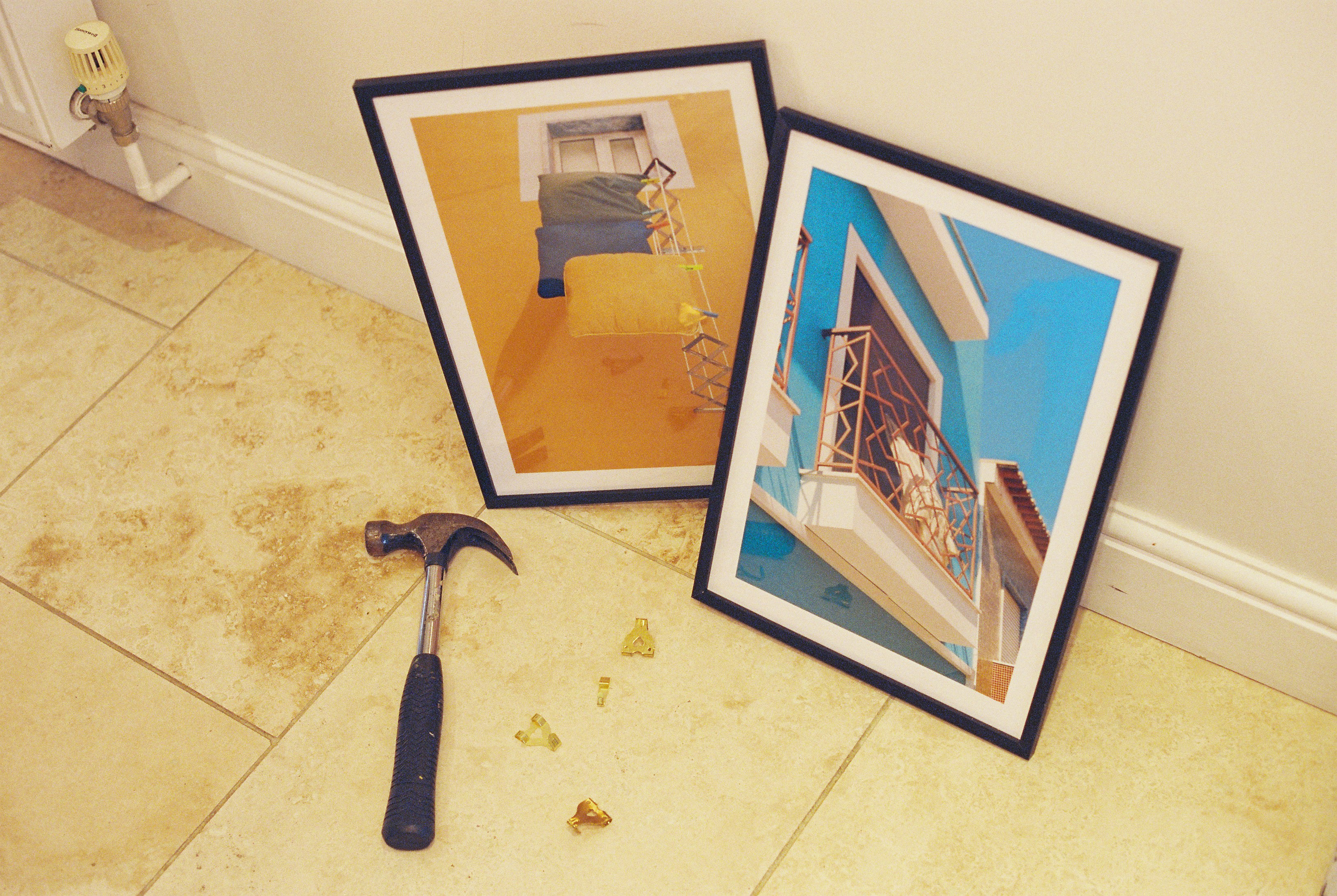 Hammer and picture frames on a tiled floor