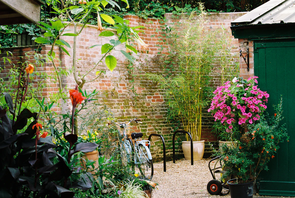 A compact brick courtyard finished with gravel paving, established planting and a timber garden shed