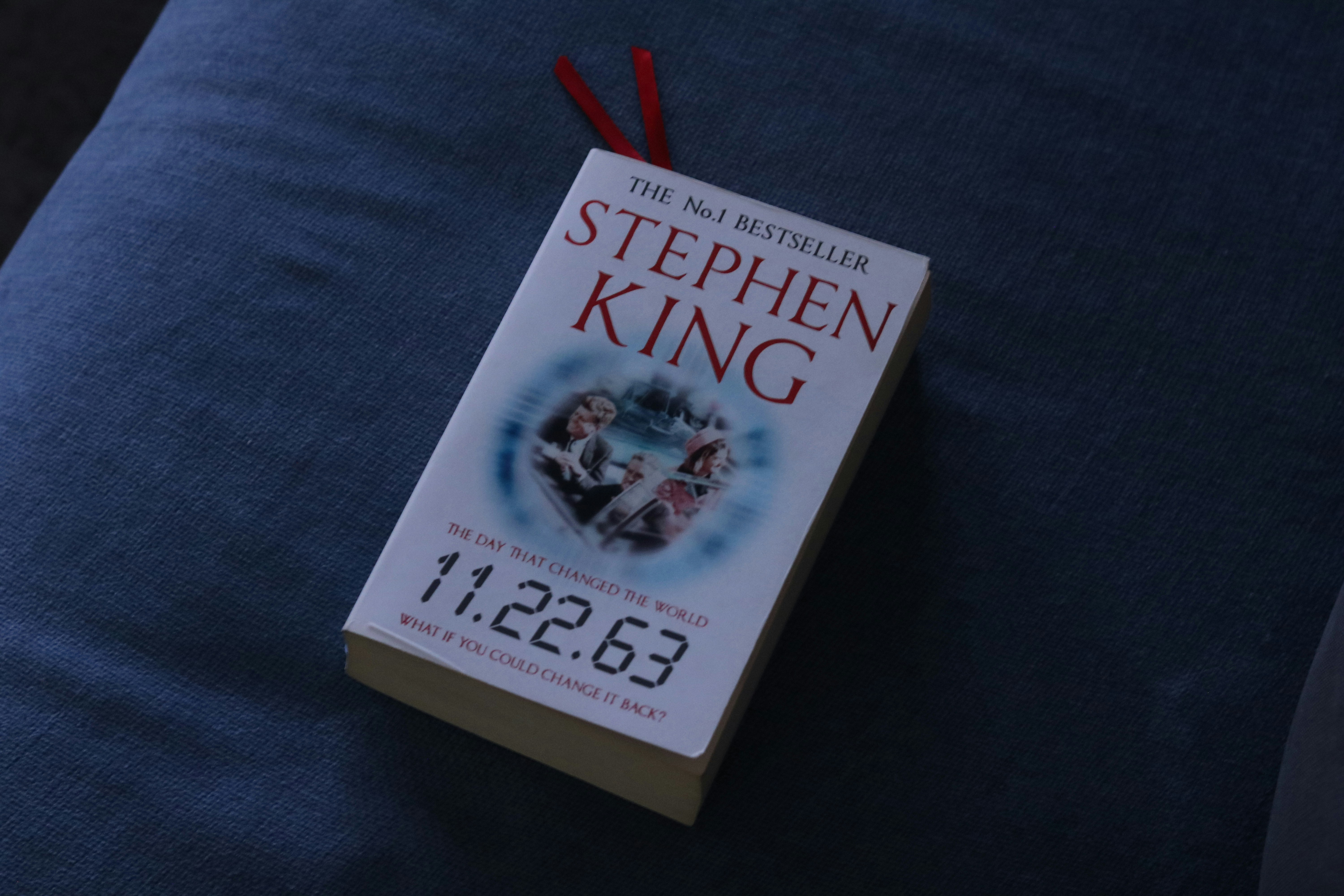 A book titled 11.22.63 by Stephen King with a red ribbon bookmark