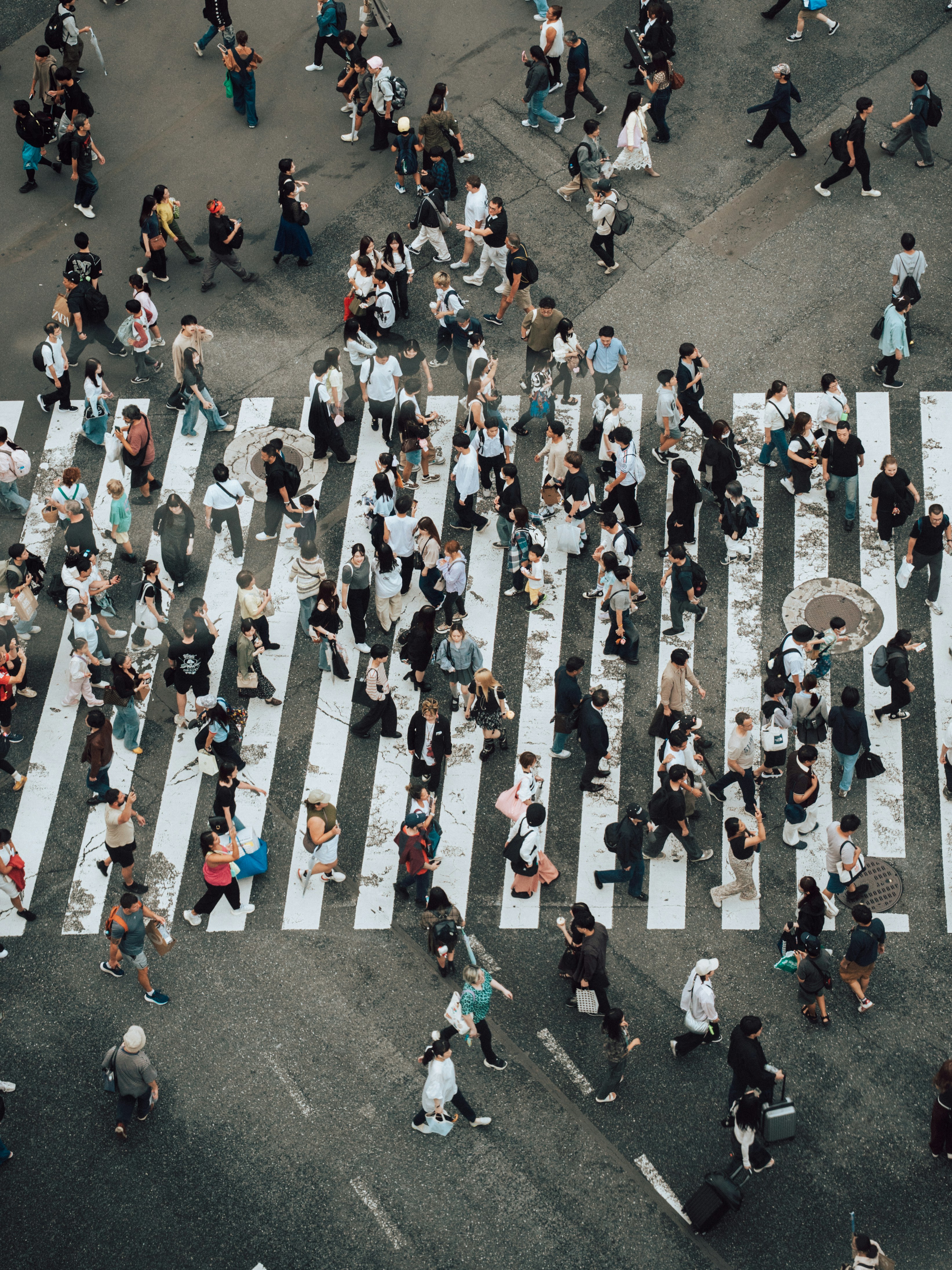A large group of people crossing a wide pedestrian crosswalk in a city - 相关推荐