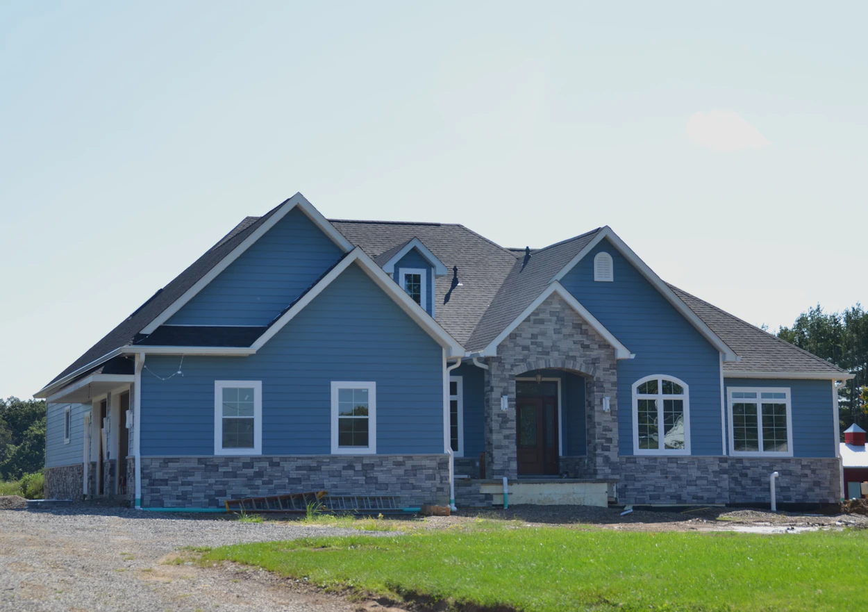 A newly finished blue home with a stone front