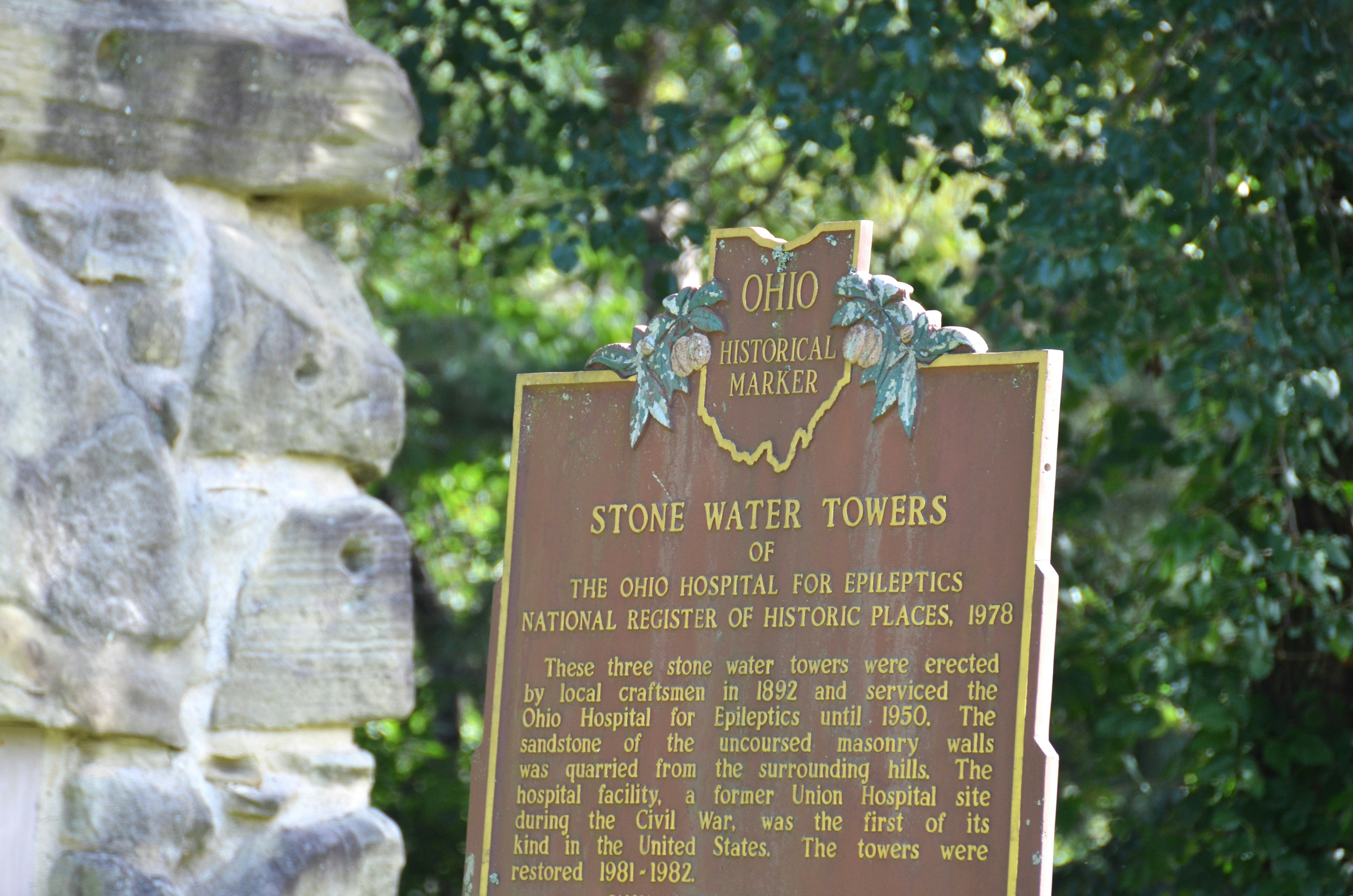 An Ohio historical marker about stone water towers near a sandstone wall - roadside historical markers