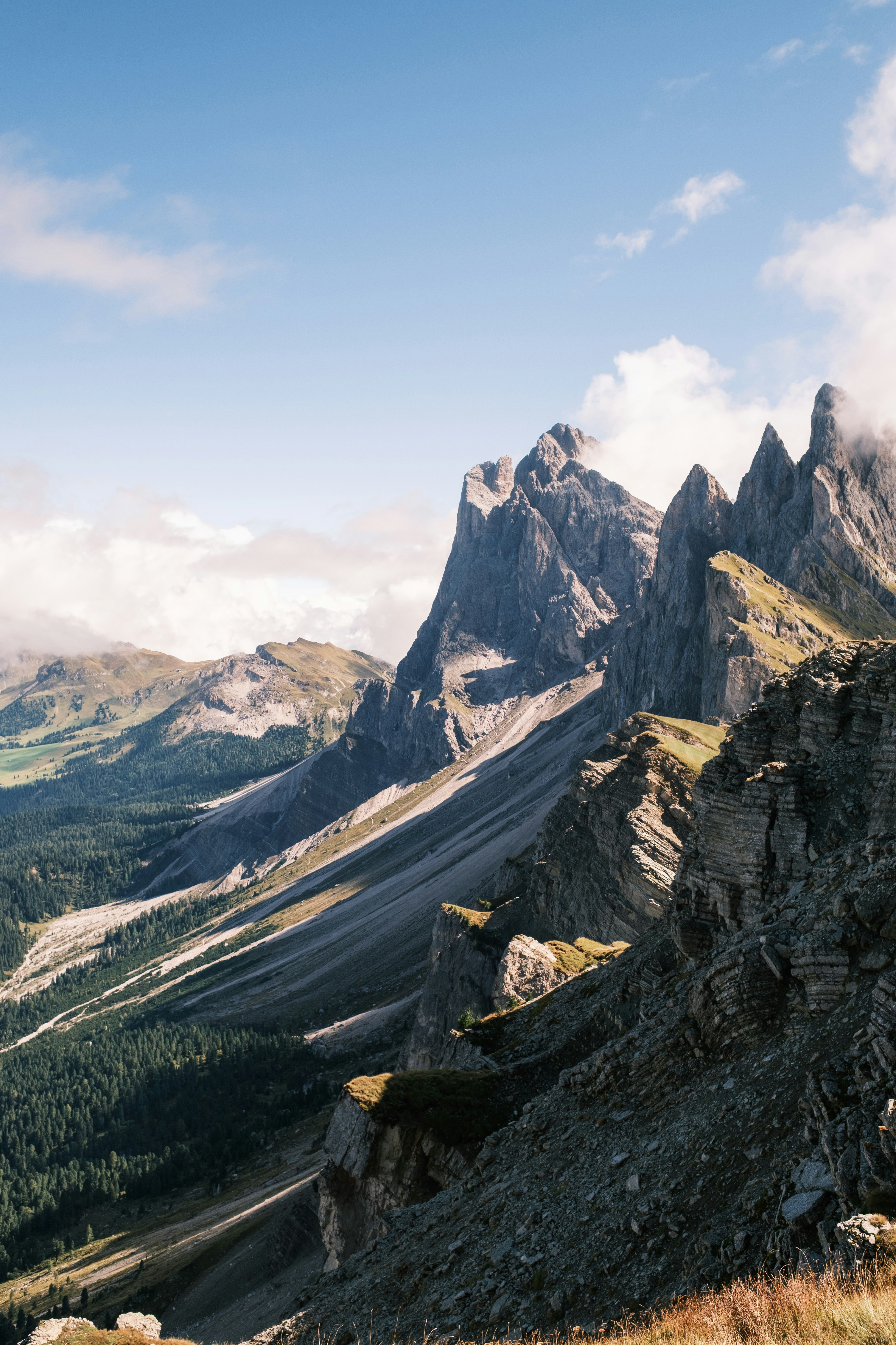 Jagged rocky peaks of the Seceda mountains rising above a green valley in Italy