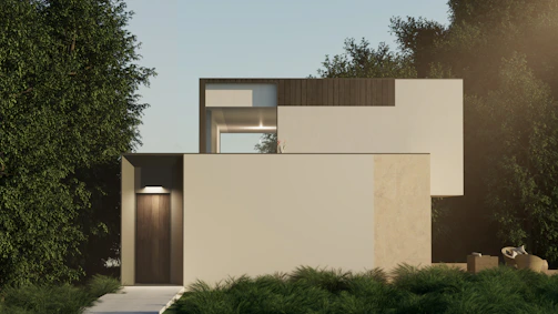 A modern minimalist house with clean lines surrounded by lush green trees