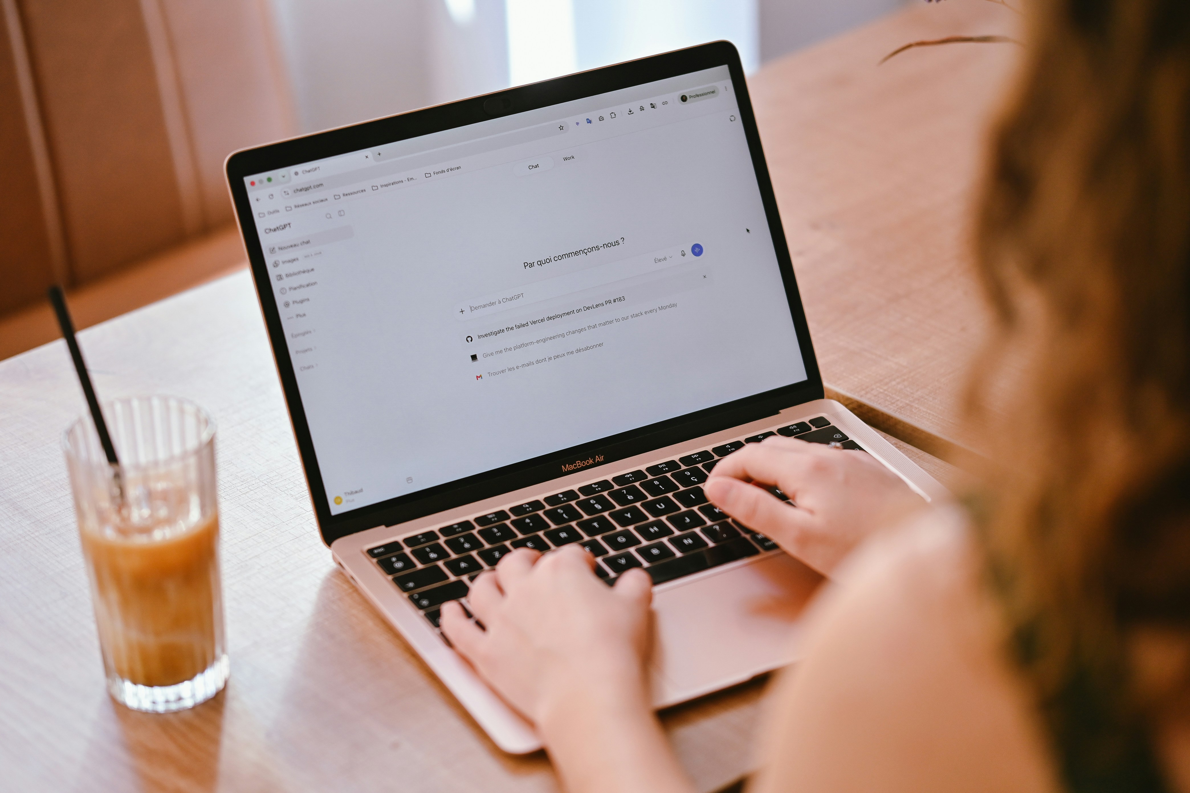 Persona trabajando en una laptop con una bebida al lado, representando a una pyme usando herramientas de inteligencia artificial.