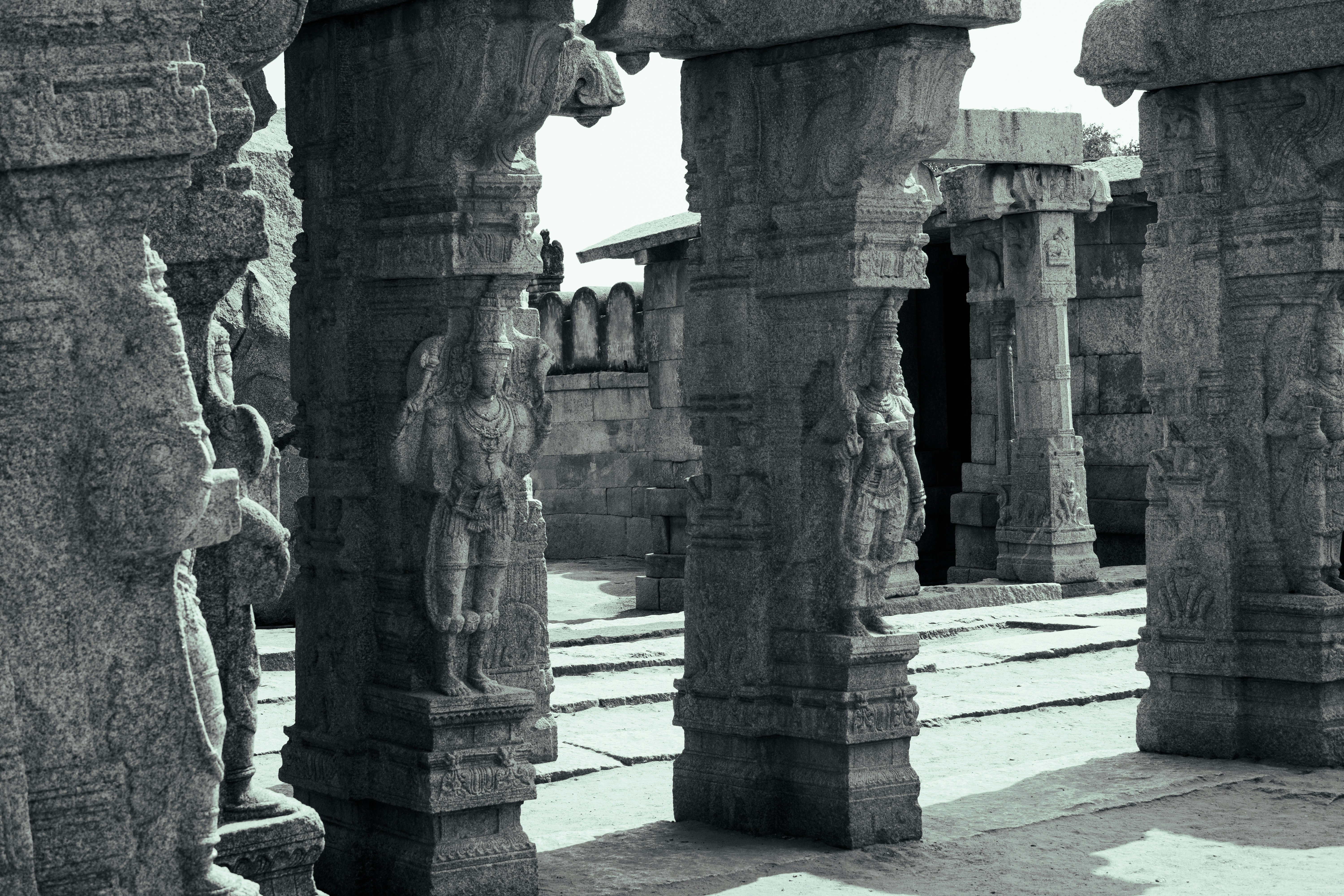 Carved stone pillars with figures in the ancient temple complex of Hampi, India